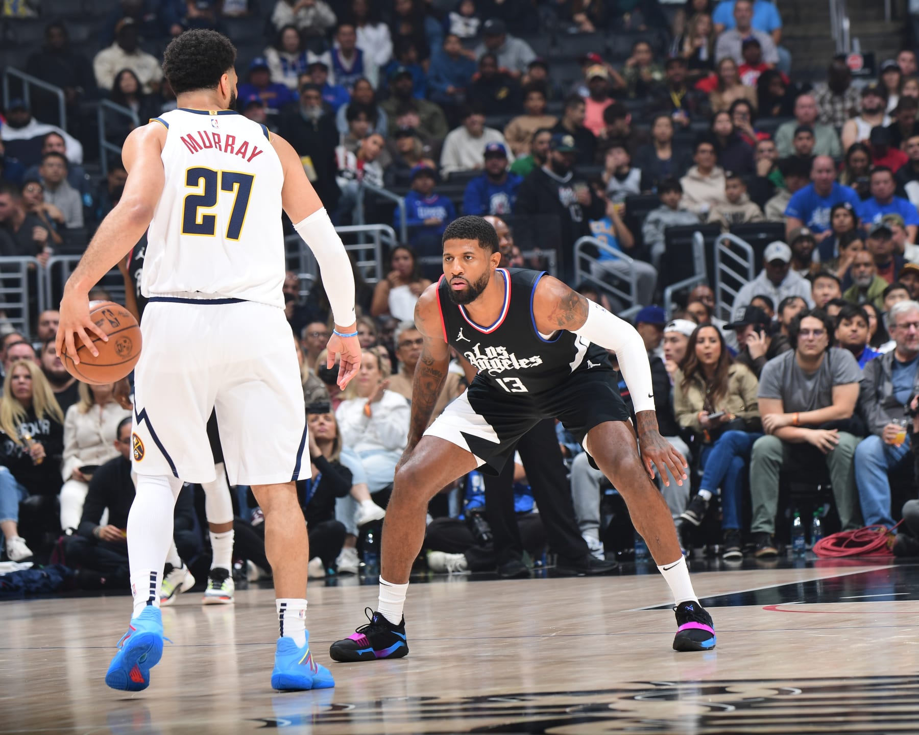 LOS ANGELES, CA - DECEMBER 6: Paul George #13 of the LA Clippers plays defense during the game  against Jamal Murray #27 of the Denver Nuggets on December 6, 2023 at Crypto.Com Arena in Los Angeles, California. NOTE TO USER: User expressly acknowledges and agrees that, by downloading and/or using this Photograph, user is consenting to the terms and conditions of the Getty Images License Agreement. Mandatory Copyright Notice: Copyright 2023 NBAE (Photo by Adam Pantozzi/NBAE via Getty Images)