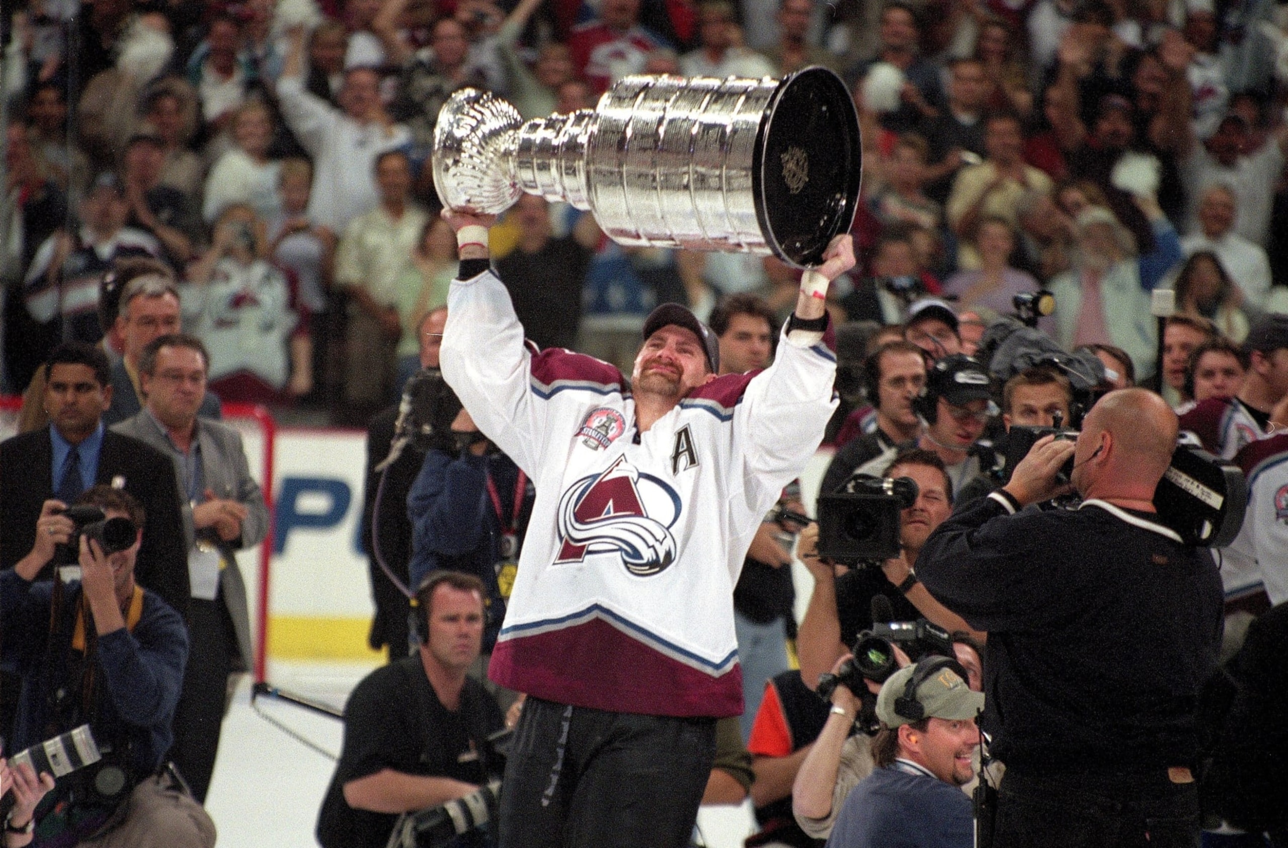 UNITED STATES - JUNE 09:  Hockey: NHL Finals, Colorado Avalanche Ray Bourque (77) victorious with Stanley Cup trophy after winning game vs New Jersey Devils, Denver, CO 6/9/2001  (Photo by Darren Carroll/Sports Illustrated via Getty Images)  (SetNumber: D44606 TK1 R1 F13)