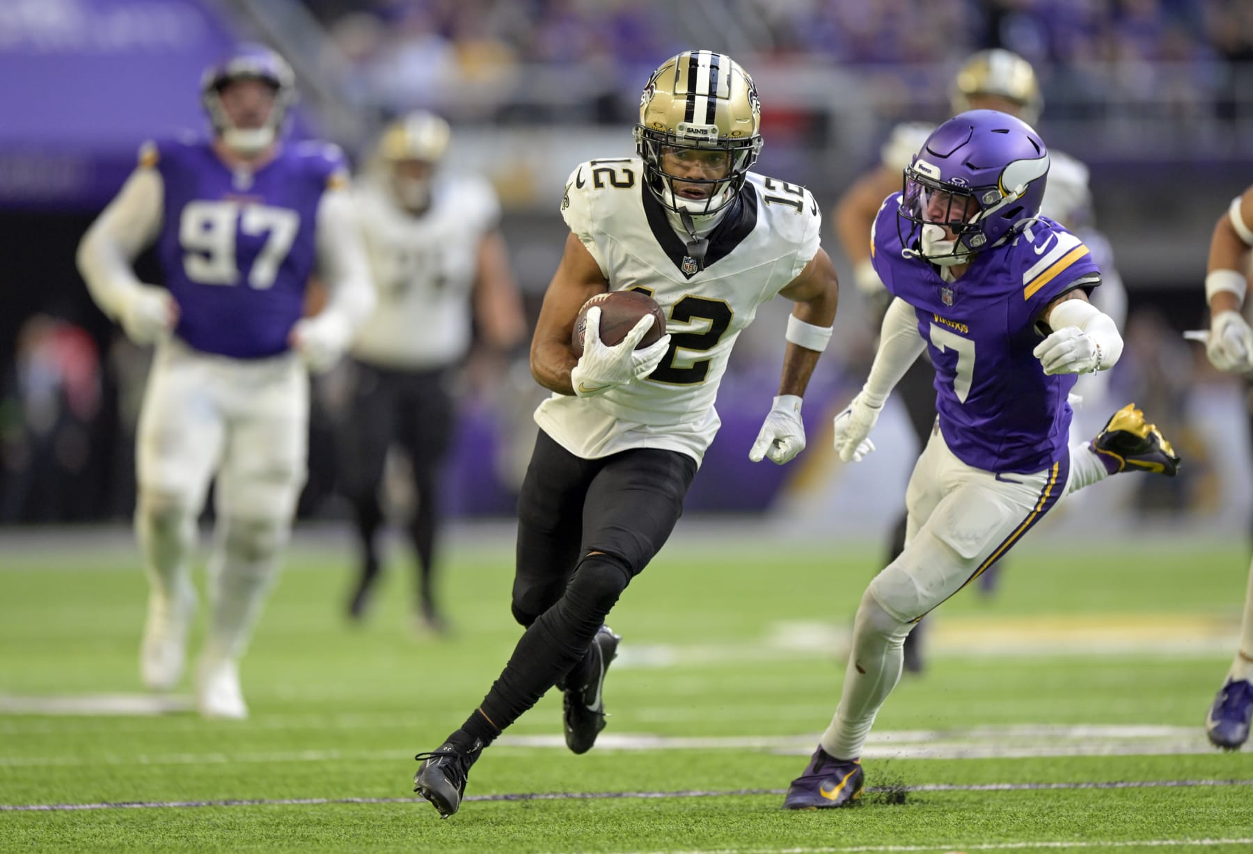 MINNEAPOLIS, MN - NOVEMBER 12: New Orleans Saints wide receiver Chris Olave (12) runs with the ball as Minnesota Vikings defensive back Byron Murphy (7) gives chase during an NFL game between the Minnesota Vikings and New Orleans Saints on November 12, 2023, at U.S. Bank Stadium in Minneapolis, MN. (Photo by Nick Wosika/Icon Sportswire via Getty Images)