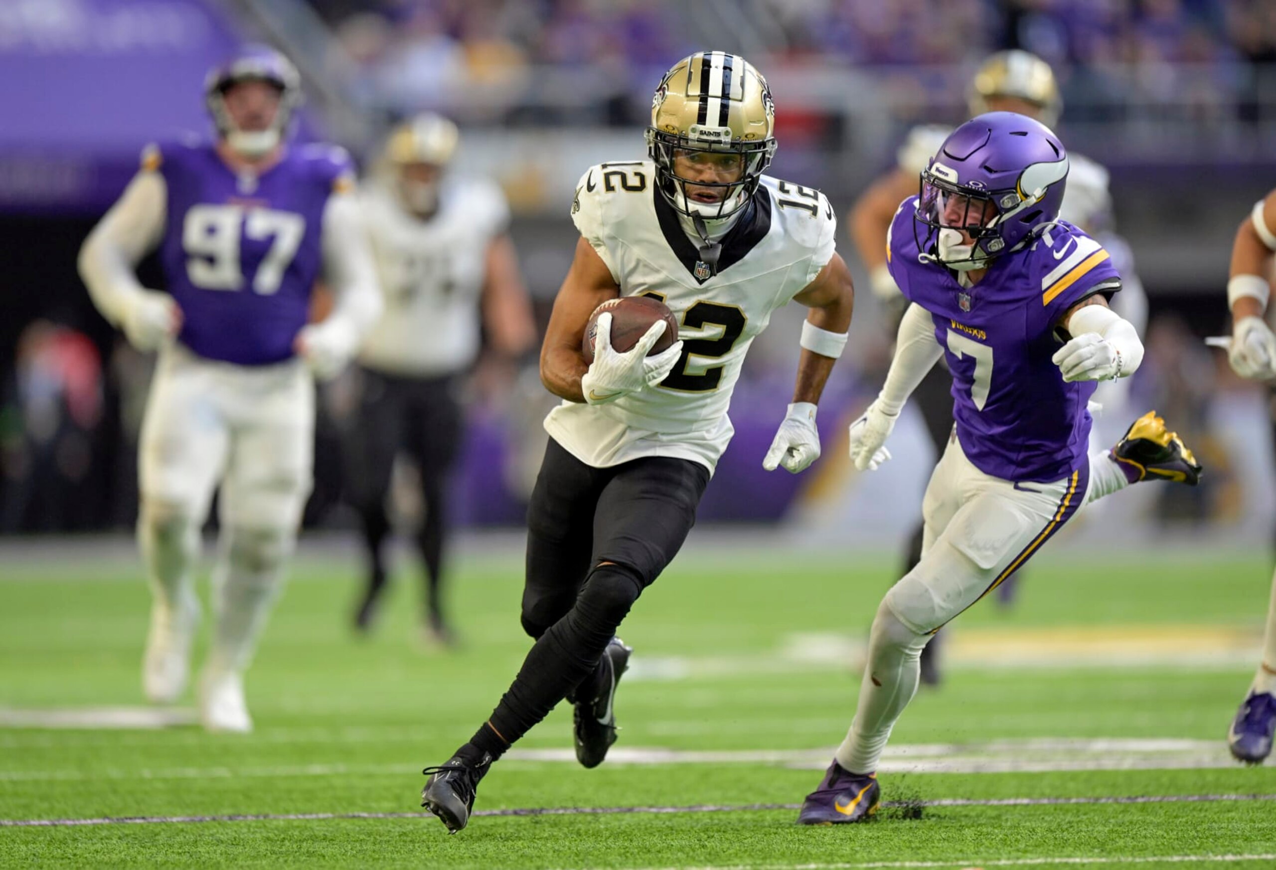 MINNEAPOLIS, MN - NOVEMBER 12: New Orleans Saints wide receiver Chris Olave (12) runs with the ball as Minnesota Vikings defensive back Byron Murphy (7) gives chase during an NFL game between the Minnesota Vikings and New Orleans Saints on November 12, 2023, at U.S. Bank Stadium in Minneapolis, MN. (Photo by Nick Wosika/Icon Sportswire via Getty Images)