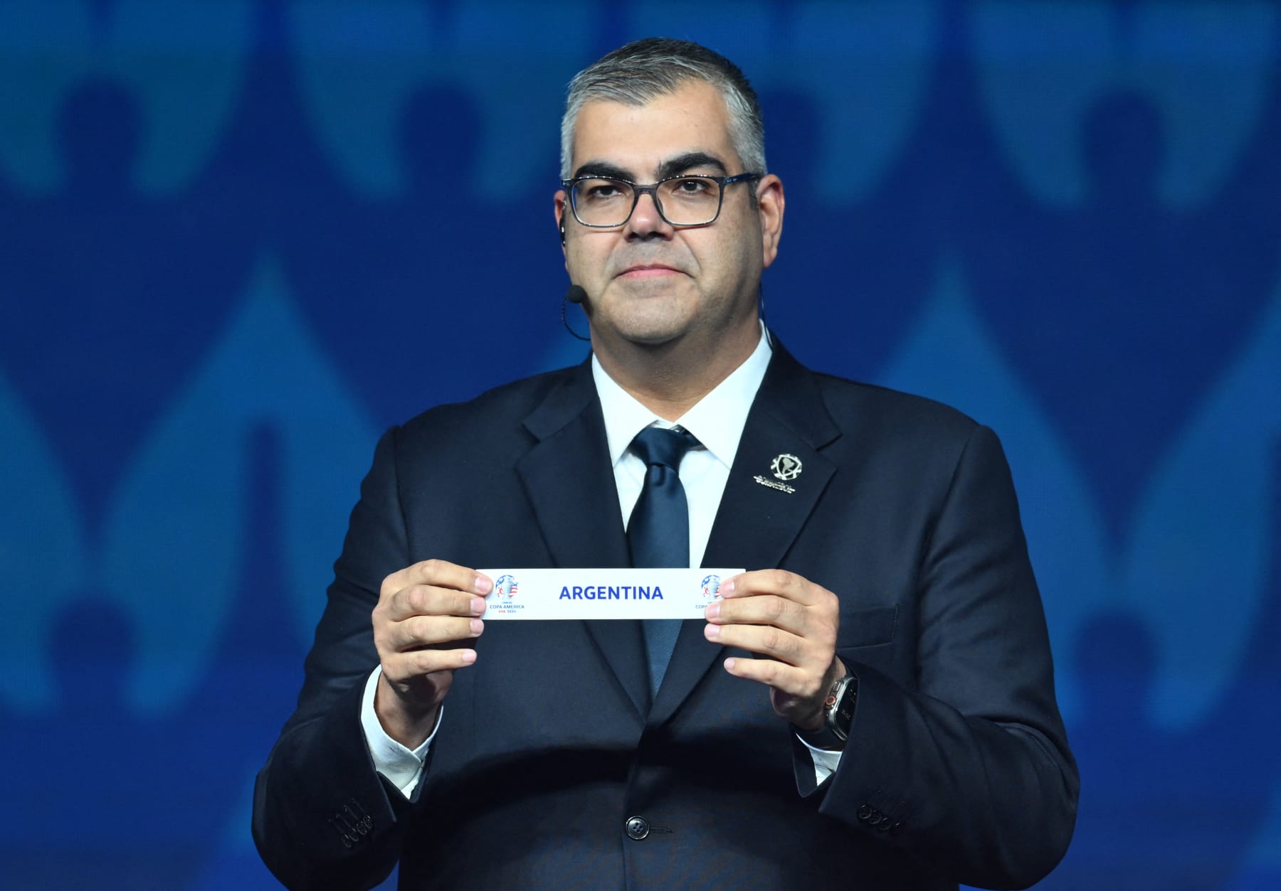 Conmebol's competition director Fred Nantes holds up a slip of paper after drawing Argentina from the pot during the final draw for the Conmebol Copa America 2024 football competition at the James L. Knight Centre in Miami, Florida, on December 7, 2023. (Photo by ANGELA WEISS / AFP) (Photo by ANGELA WEISS/AFP via Getty Images)