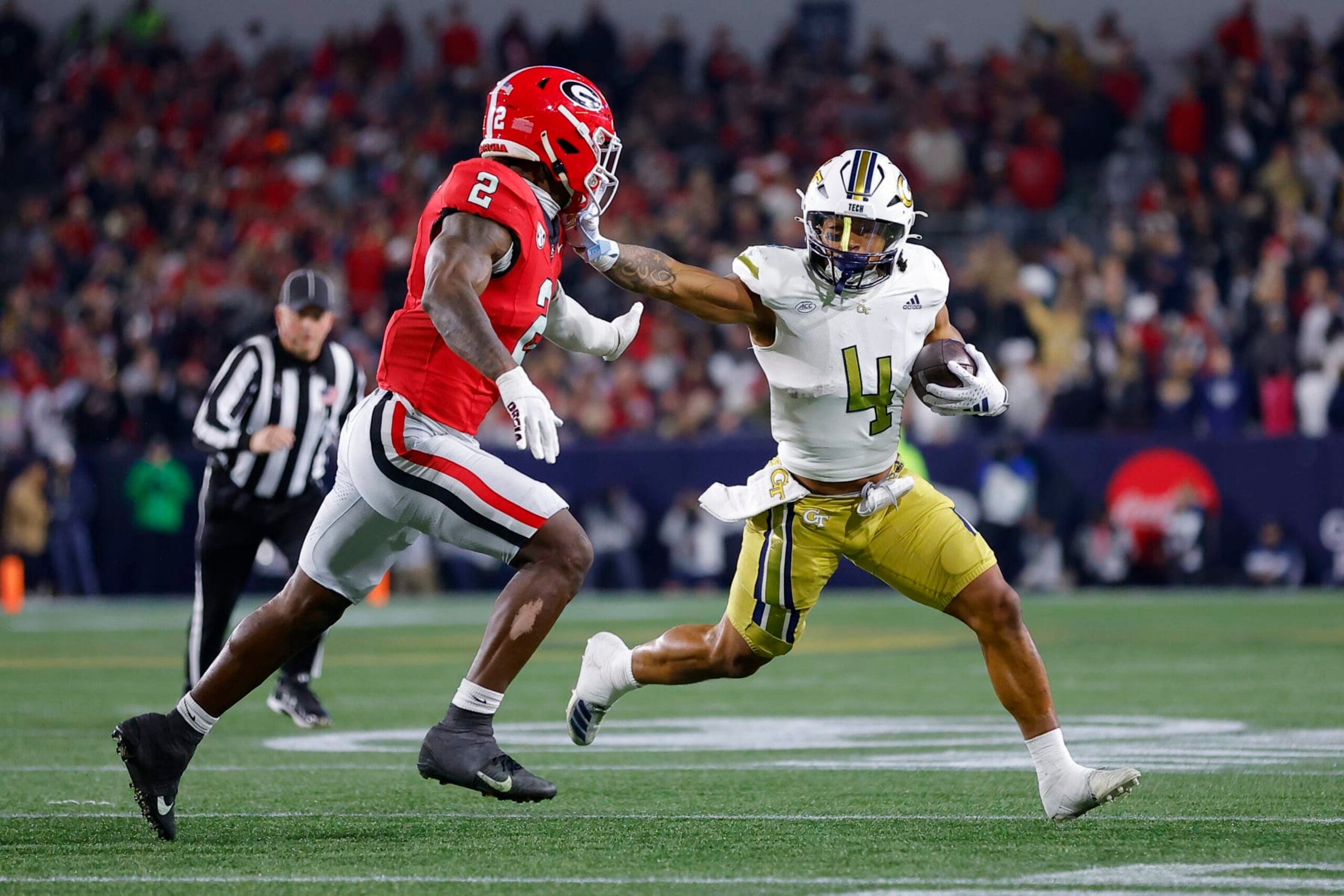 ATLANTA, GEORGIA - NOVEMBER 25: Dontae Smith #4 of the Georgia Tech Yellow Jackets stiff arms Smael Mondon Jr. #2 of the Georgia Bulldogs during the first quarter at Bobby Dodd Stadium on November 25, 2023 in Atlanta, Georgia. (Photo by Todd Kirkland/Getty Images)