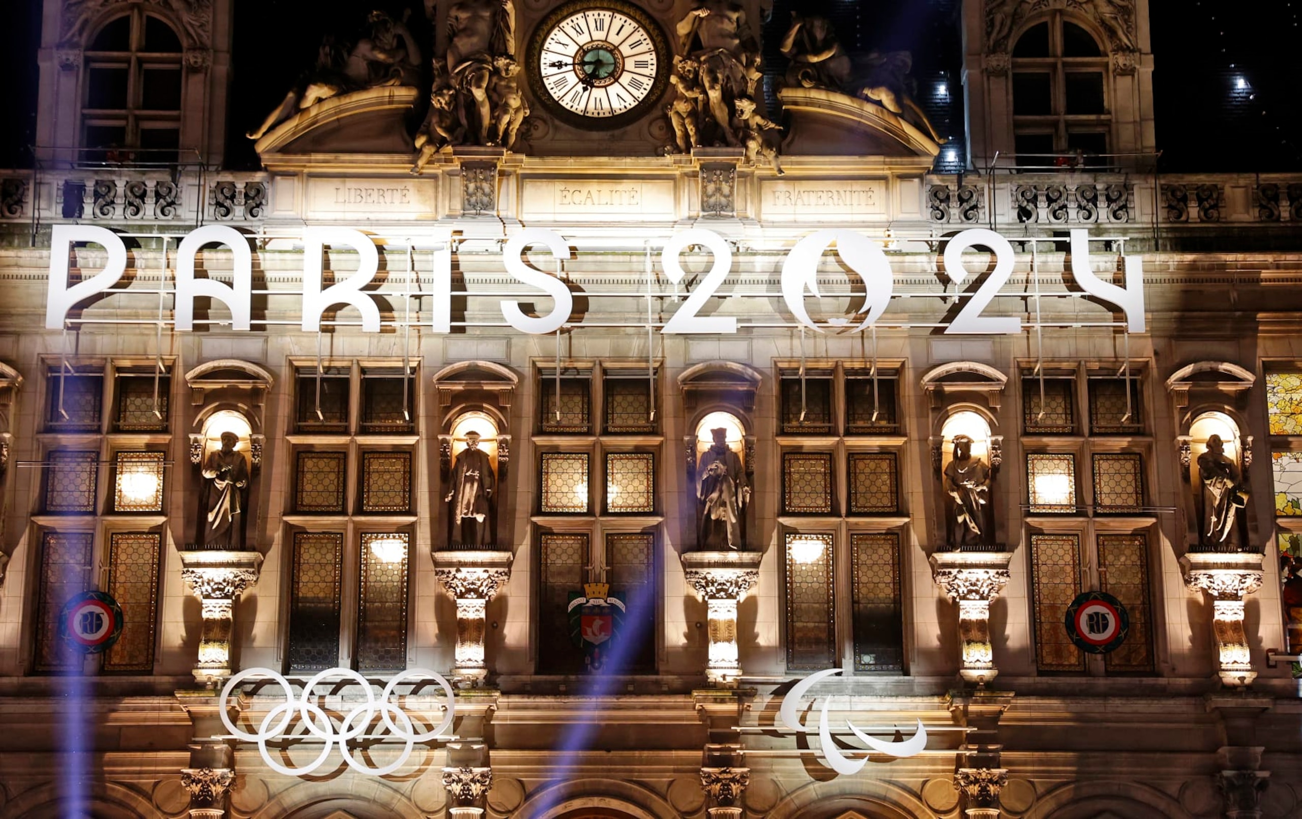 PARIS, FRANCE - NOVEMBER 28: The logo, Paris 2024 representing the Olympic Games, several months prior to the start of the Paris 2024 Olympic and Paralympic Games is displayed on the illumined facade of Paris town hall on November 28, 2023 in Paris, France. France will host the Olympic Games on Friday July 26 to Sunday August 11, 2024. (Photo by Chesnot/Getty Images)