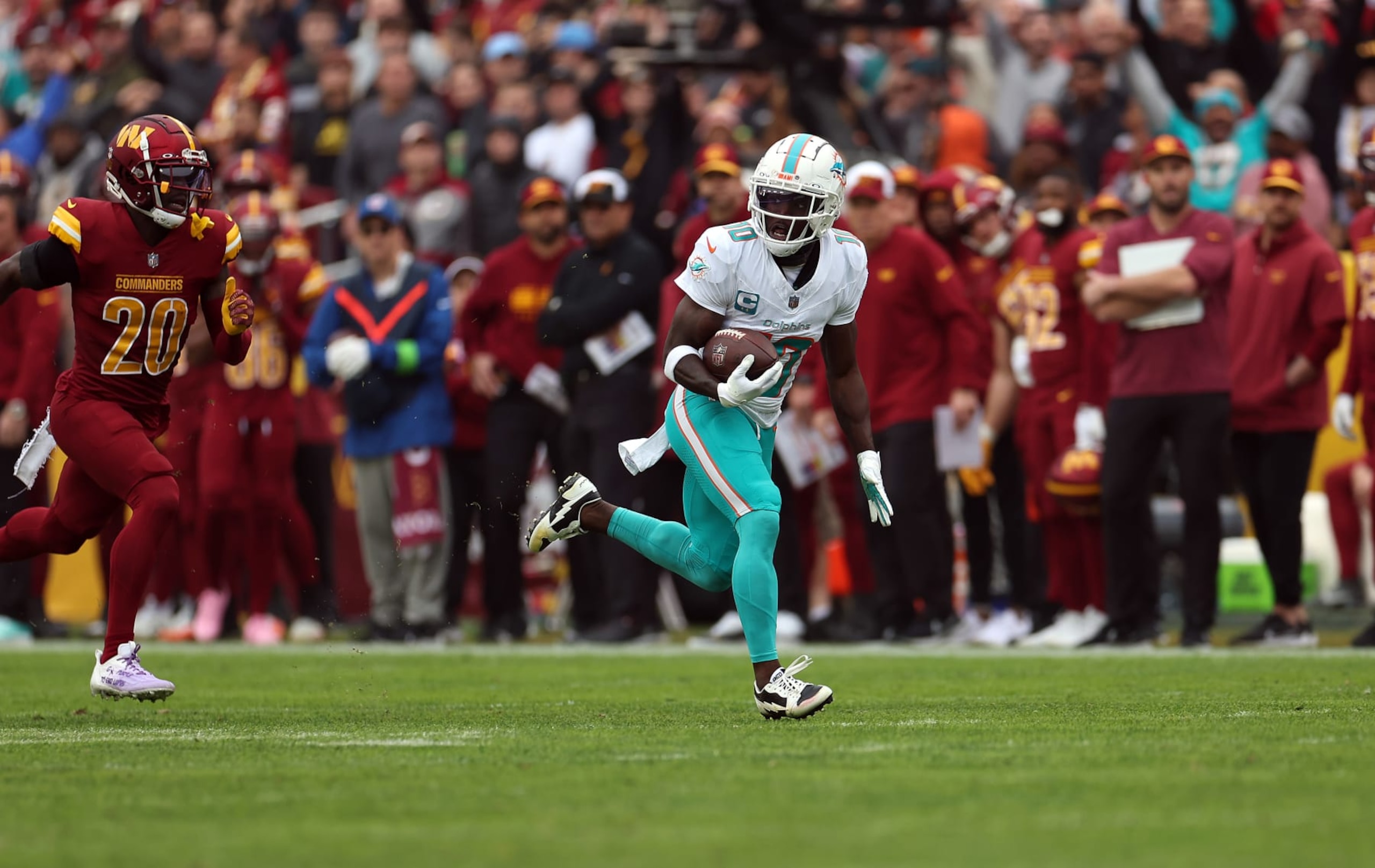 LANDOVER, MARYLAND - DECEMBER 03: Tyreek Hill #10 of the Miami Dolphins carries the ball for a touchdown against the Washington Commanders during the first quarter of the game at FedExField on December 03, 2023 in Landover, Maryland. (Photo by Rob Carr/Getty Images)