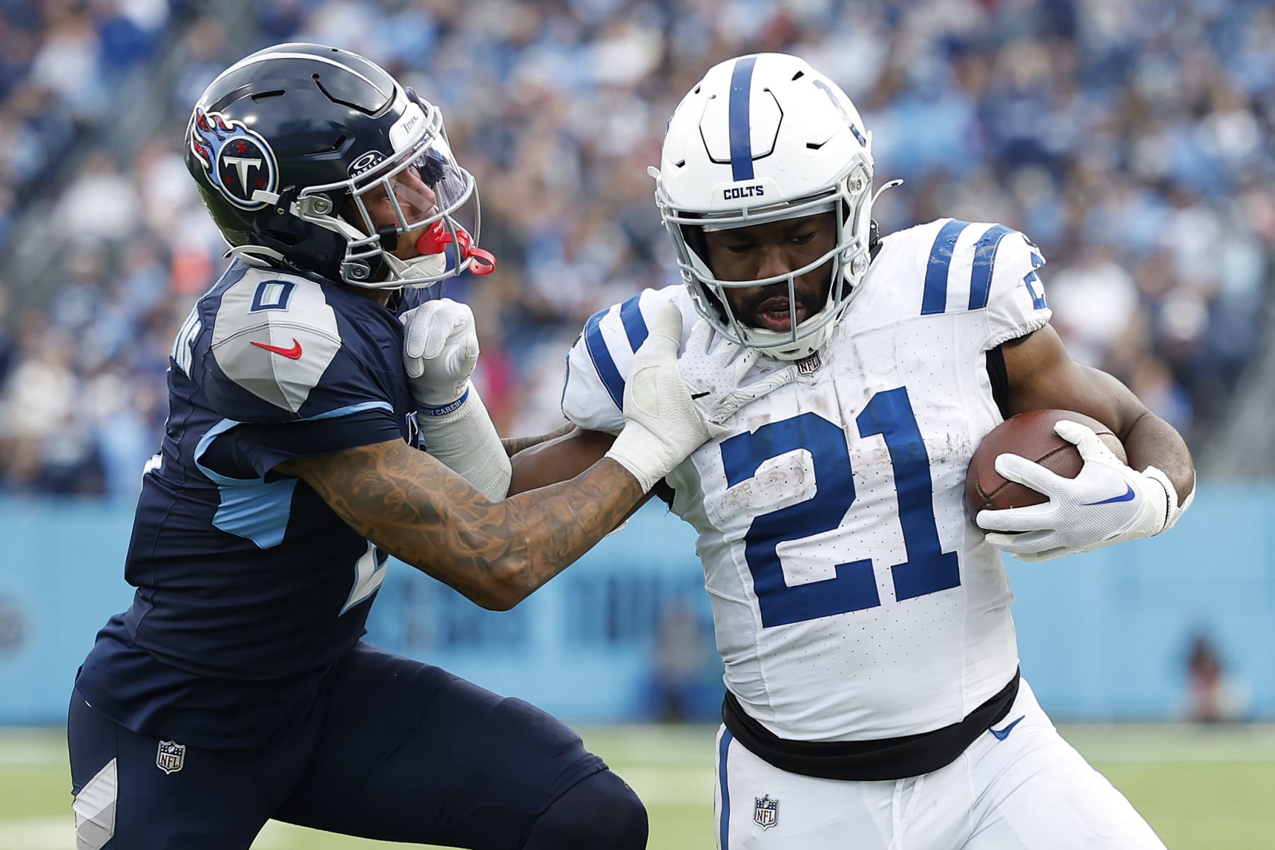 NASHVILLE, TENNESSEE - DECEMBER 03: Zack Moss #21 of the Indianapolis Colts carries the ball against Sean Murphy-Bunting #0 of the Tennessee Titans during the second half at Nissan Stadium on December 03, 2023 in Nashville, Tennessee. (Photo by Wesley Hitt/Getty Images)