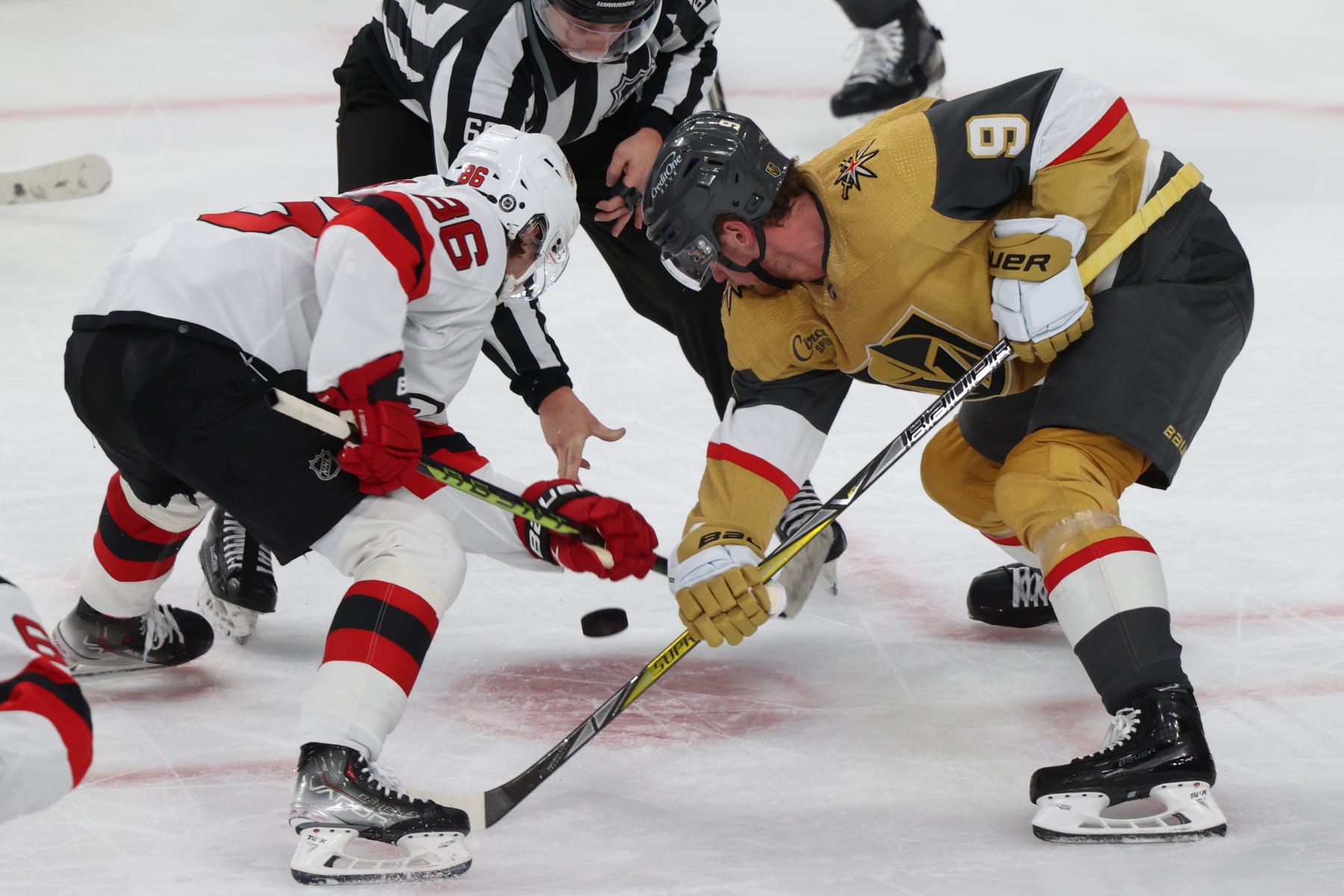 New Jersey Devils center Jack Hughes (left) faces off against Vegas Golden Knights center Jack Eichel 