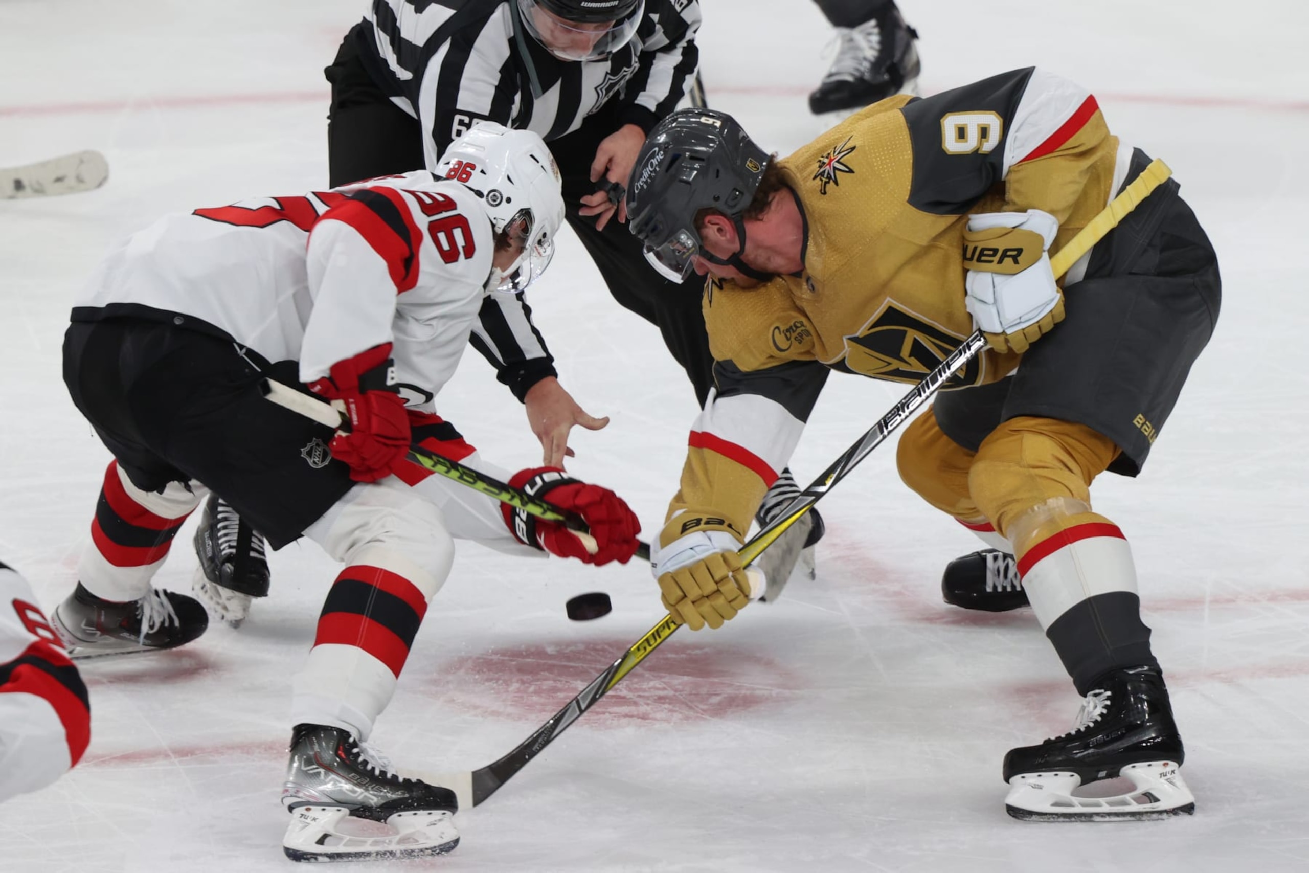 New Jersey Devils center Jack Hughes (left) faces off against Vegas Golden Knights center Jack Eichel 