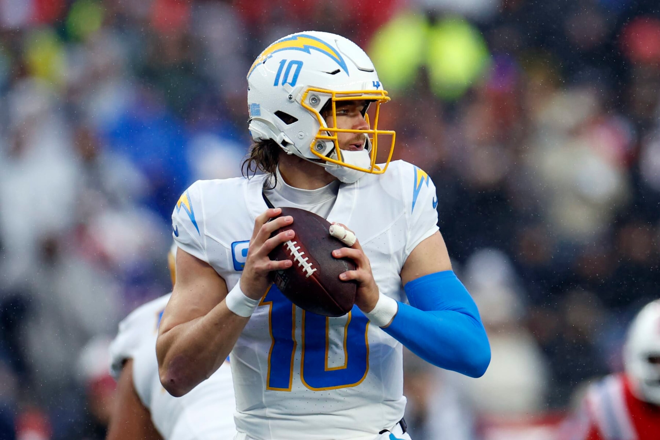 Foxborough, MA - December 3: Los Angeles Chargers QB Justin Herbert seeks out a receiver in the first half. The Chargers beat the New England Patriots, 6-0. (Photo by Danielle Parhizkaran/The Boston Globe via Getty Images)