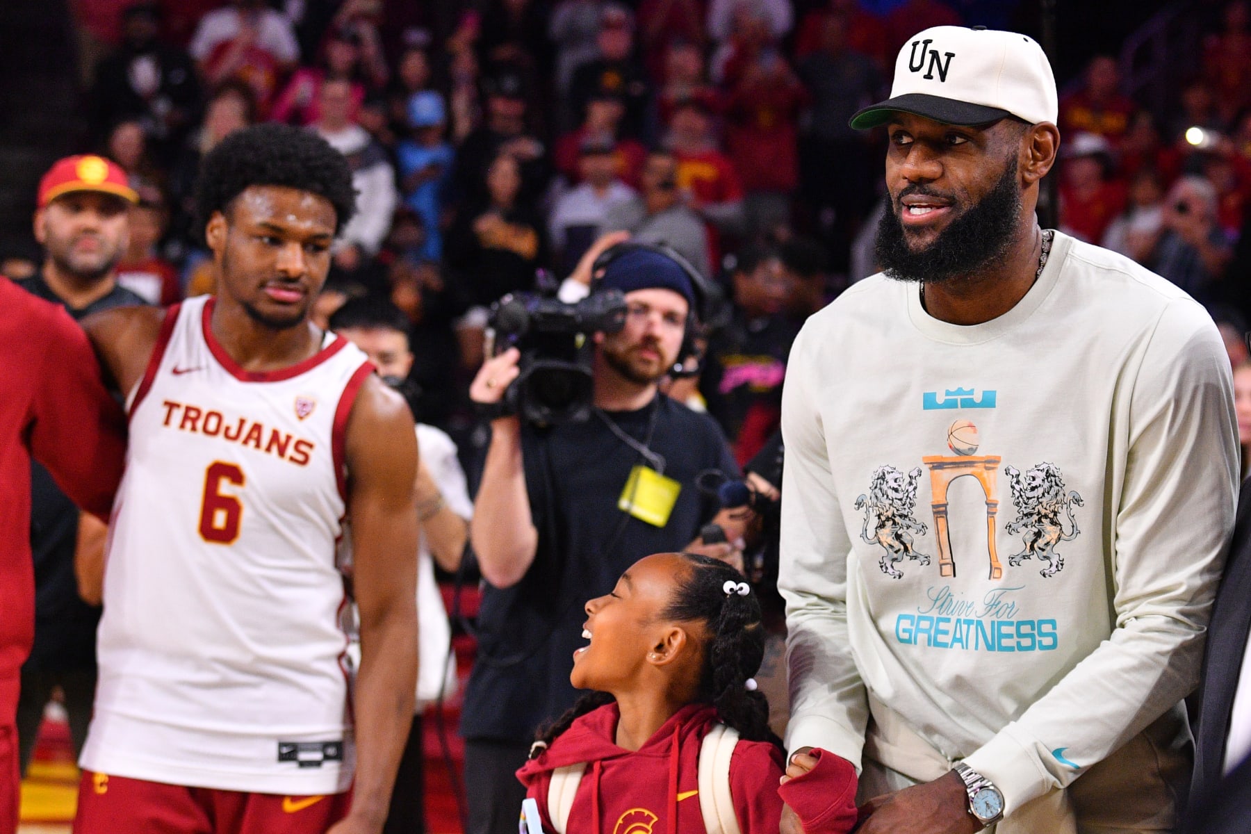 LOS ANGELES, CA - DECEMBER 10: Los Angeles Lakers forward Lebron James and his daughter Zhuri Nova walk past USC Trojans guard Bronny James (6) before the college basketball game between the Long Beach State 49ers and the USC Trojans on December 10, 2023 at Galen Center in Los Angeles, CA. (Photo by Brian Rothmuller/Icon Sportswire via Getty Images)