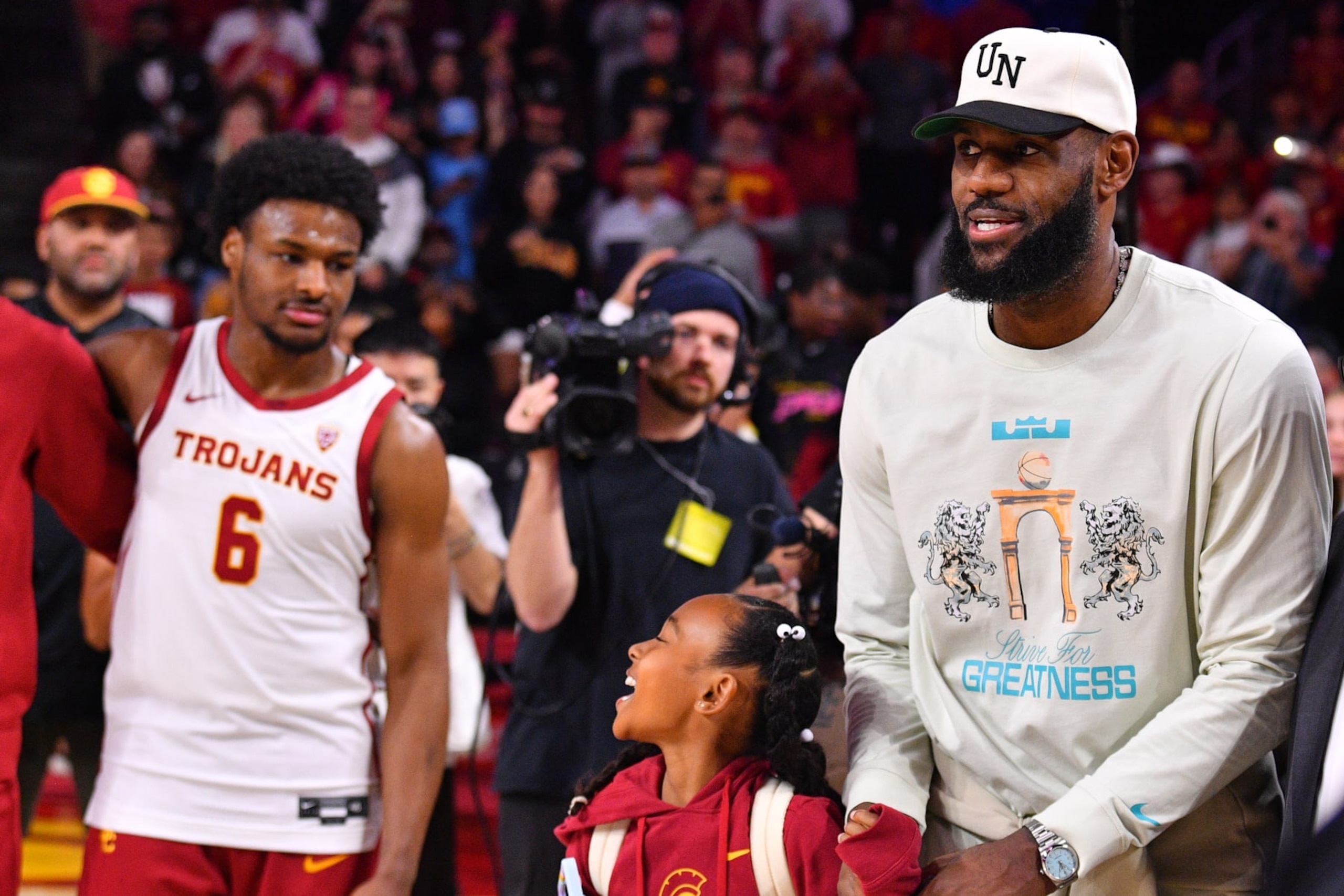 LOS ANGELES, CA - DECEMBER 10: Los Angeles Lakers forward Lebron James and his daughter Zhuri Nova walk past USC Trojans guard Bronny James (6) before the college basketball game between the Long Beach State 49ers and the USC Trojans on December 10, 2023 at Galen Center in Los Angeles, CA. (Photo by Brian Rothmuller/Icon Sportswire via Getty Images)