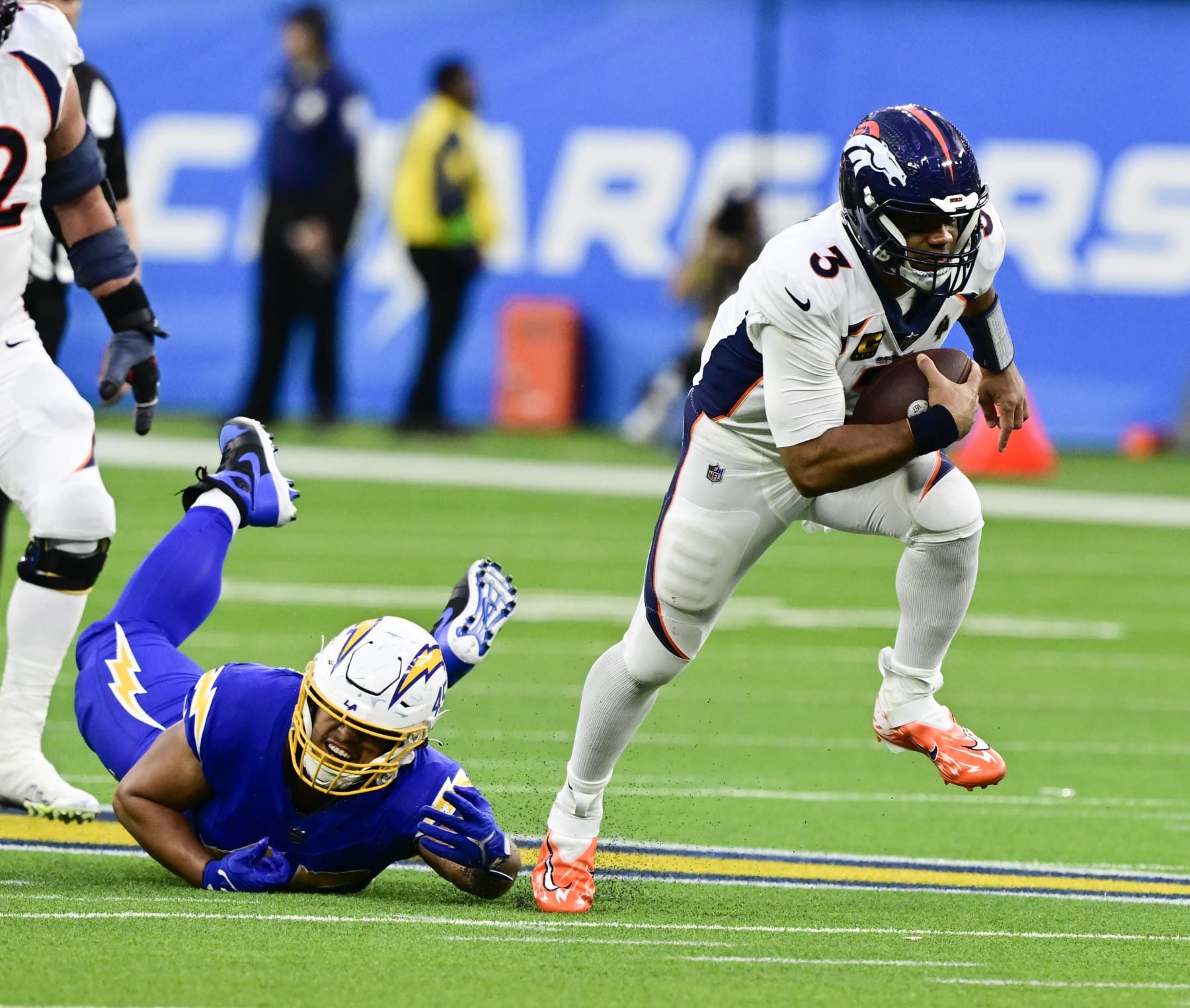 INGLEWOOD, CA - DECEMBER 10: Denver Broncos quarterback Russell Wilson (3) eludes Los Angeles Chargers linebacker Tuli Tuipulotu (45) on a keeper for aa first down in the fourth quarter at SoFi Stadium in Inglewood, California Sunday December 10, 2023. (Photo by Andy Cross/MediaNews Group/The Denver Post via Getty Images)