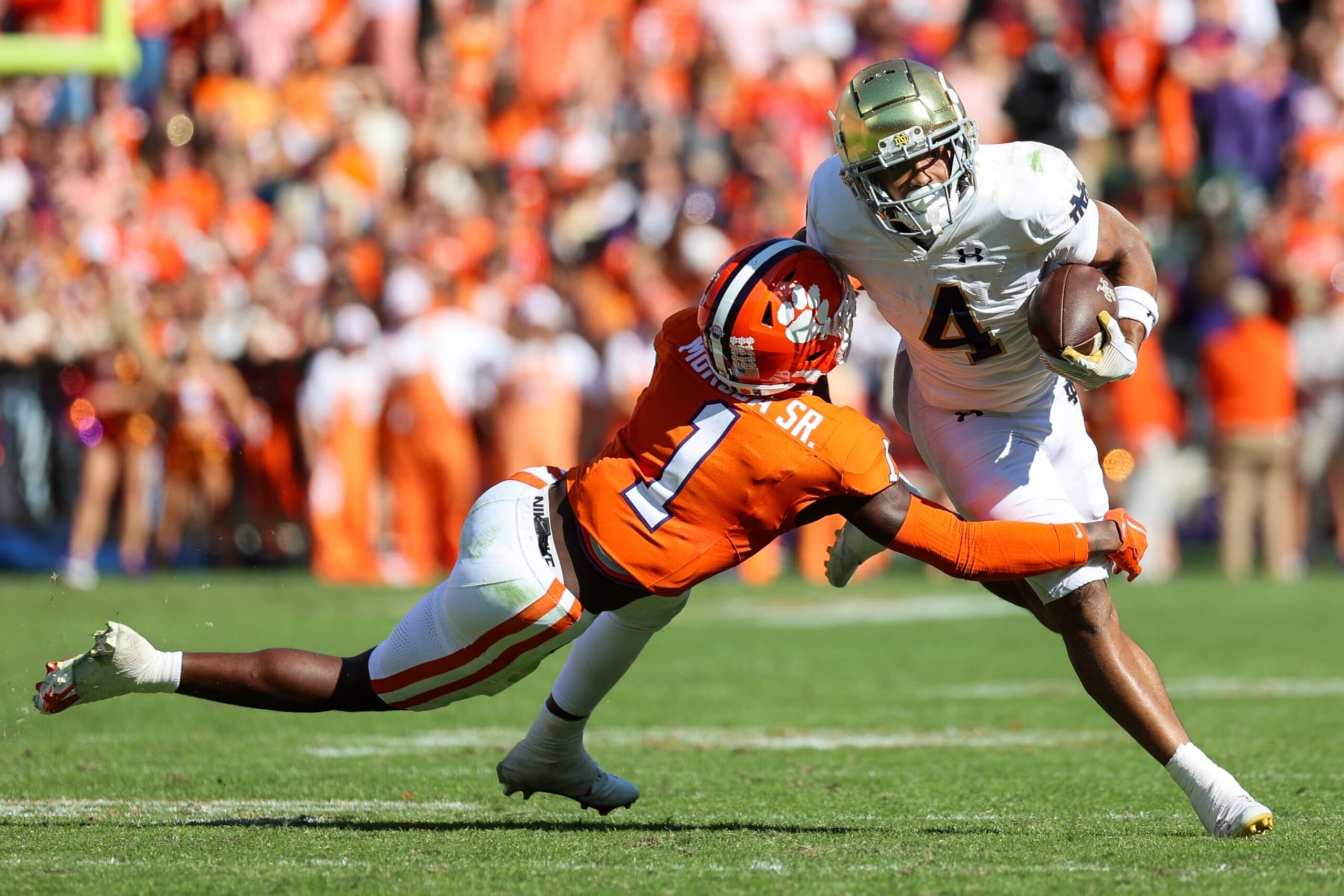 CLEMSON, SOUTH CAROLINA - NOVEMBER 4: Chris Tyree #4 of the Notre Dame Fighting Irish tries to break a tackle from Andrew Mukuba #1 of the Clemson Tigers at Memorial Stadium on November 4, 2023 in Clemson, South Carolina. (Photo by Isaiah Vazquez/Getty Images)
