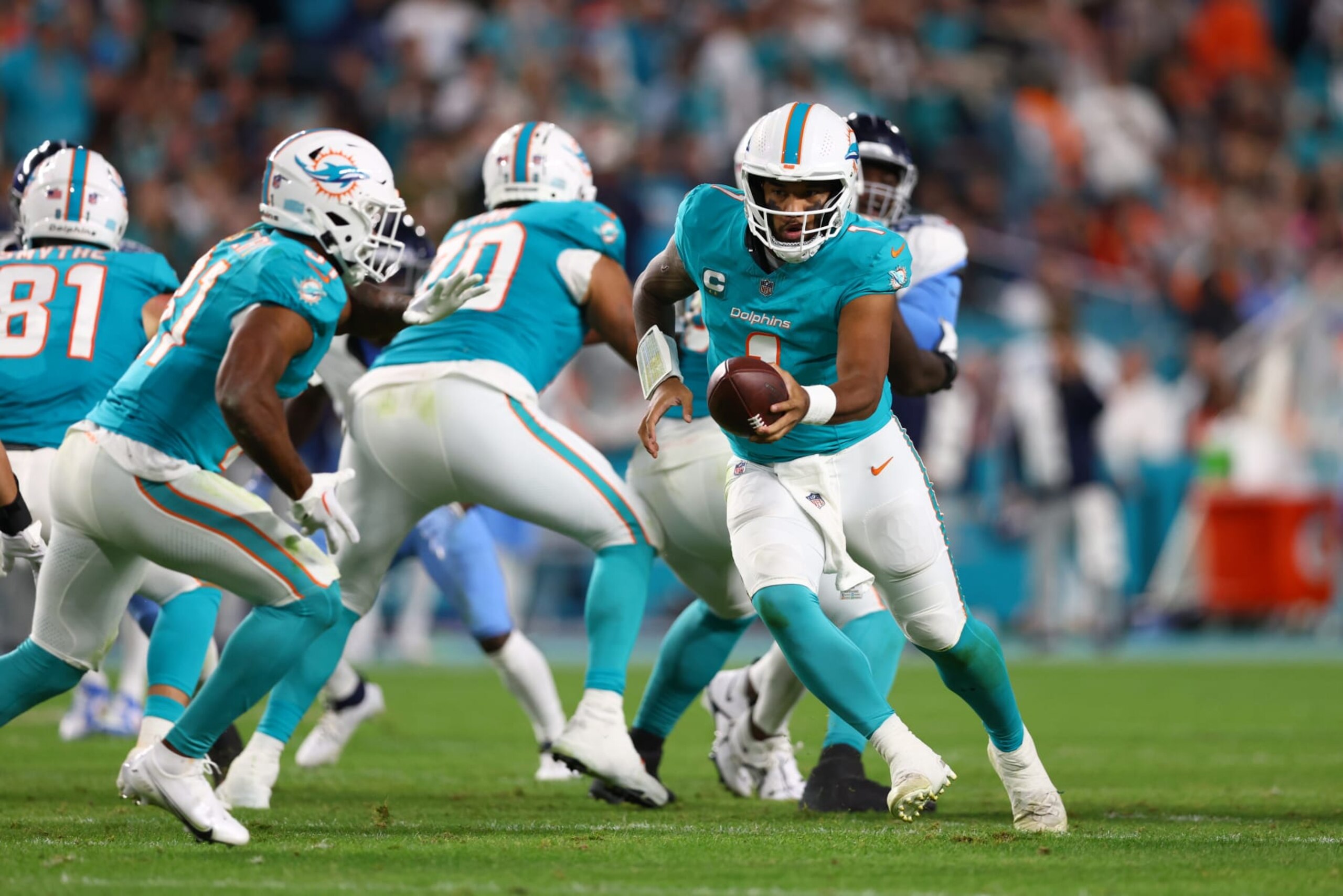MIAMI GARDENS, FLORIDA - DECEMBER 11: Tua Tagovailoa #1 of the Miami Dolphins hands off to Raheem Mostert #31 of the Miami Dolphins in the second half at Hard Rock Stadium on December 11, 2023 in Miami Gardens, Florida. (Photo by Megan Briggs/Getty Images)