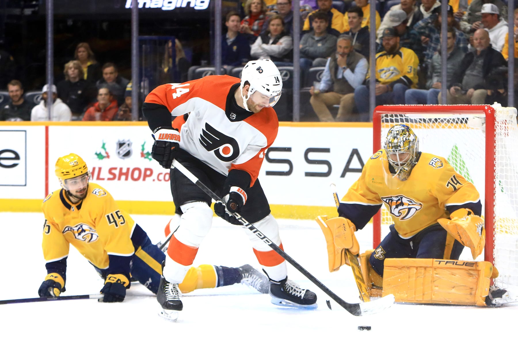 NASHVILLE, TN - DECEMBER 12: Nashville Predators goalie Juuse Saros (74) and defenseman Alexandre Carrier (45) defend against Philadelphia Flyers center Sean Couturier (14) during the NHL game between the Nashville Predators and Philadelphia Flyers, held on December 12, 2023, at Bridgestone Arena in Nashville, Tennessee. (Photo by Danny Murphy/Icon Sportswire via Getty Images)