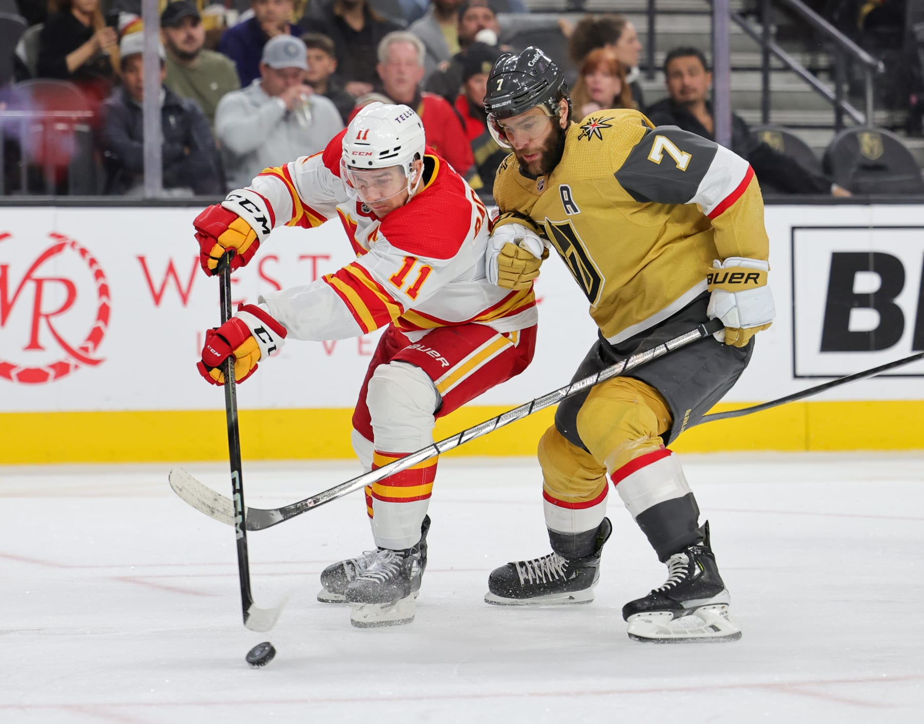 LAS VEGAS, NEVADA - DECEMBER 12: Mikael Backlund #11 of the Calgary Flames skates with the puck against Alex Pietrangelo #7 of the Vegas Golden Knights in the third period of their game at T-Mobile Arena on December 12, 2023 in Las Vegas, Nevada. The Golden Knights defeated the Flames 5-4 in overtime. (Photo by Ethan Miller/Getty Images)