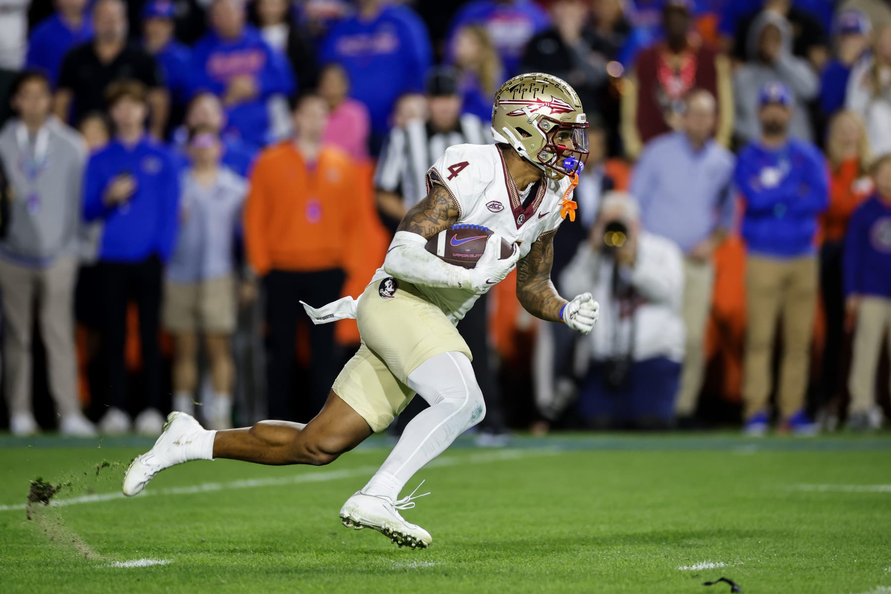 GAINESVILLE, FLORIDA - NOVEMBER 25: Keon Coleman #4 of the Florida State Seminoles runs with the ball  during the second half of a game against the Florida Gators at Ben Hill Griffin Stadium on November 25, 2023 in Gainesville, Florida. (Photo by James Gilbert/Getty Images)