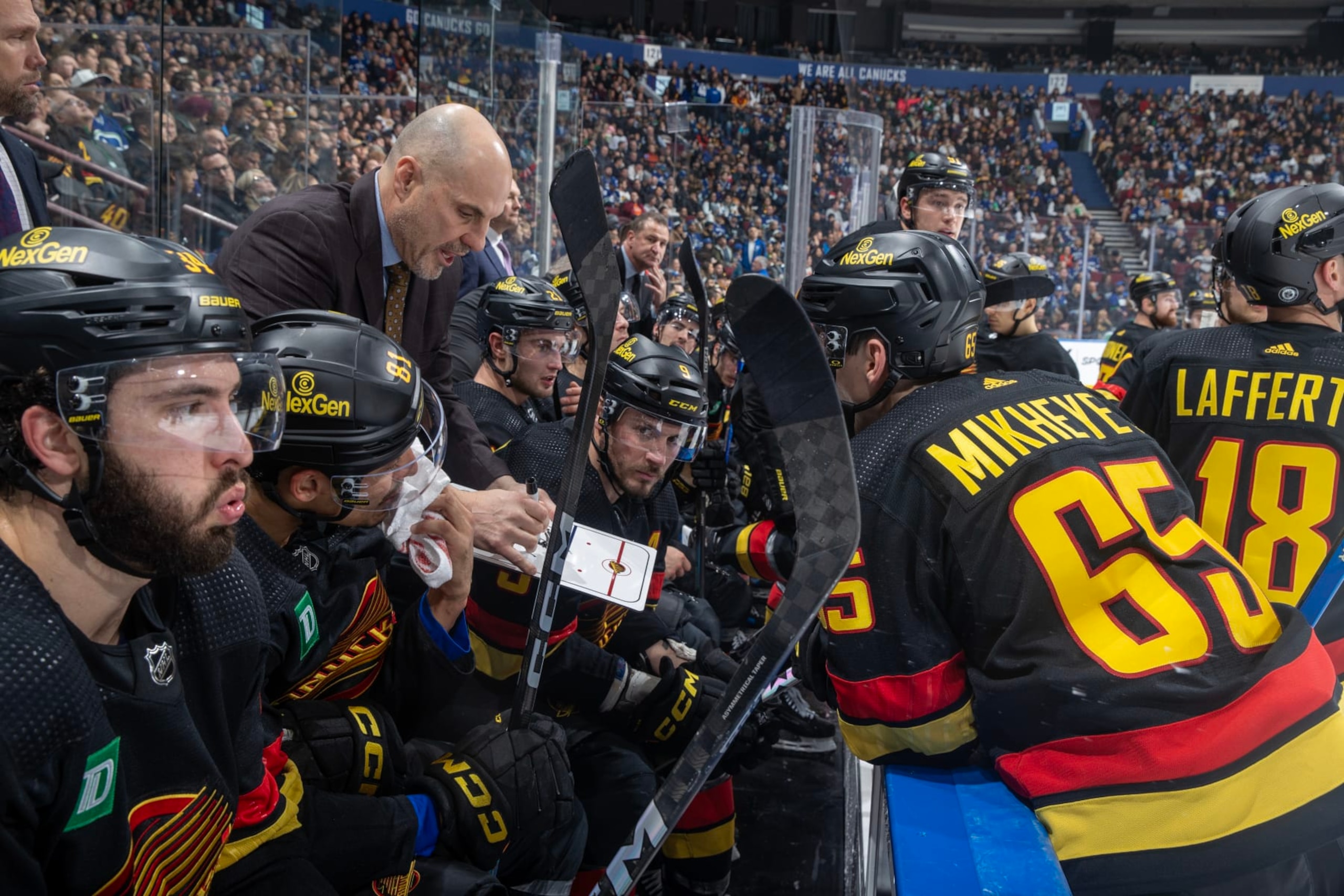 VANCOUVER, CANADA - DECEMBER 12: Head coach Rick Tocchet of the Vancouver Canucks discusses strategies during the timeout in the third period of their NHL game against the Tampa Bay Lightning at Rogers Arena on December 12, 2023 in Vancouver, British Columbia, Canada.  (Photo by Jeff Vinnick/NHLI via Getty Images)