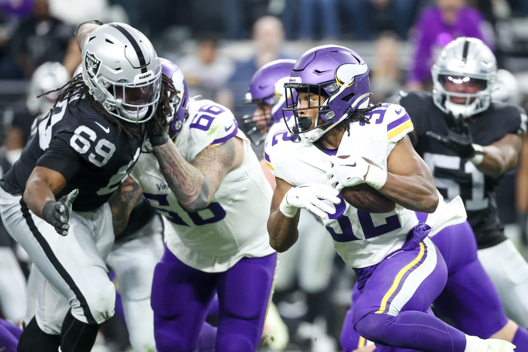 LAS VEGAS, NEVADA - DECEMBER 10: Ty Chandler #32 of the Minnesota Vikings runs past Adam Butler #69 of the Las Vegas Raiders during the third quarter at Allegiant Stadium on December 10, 2023 in Las Vegas, Nevada. (Photo by Ian Maule/Getty Images)