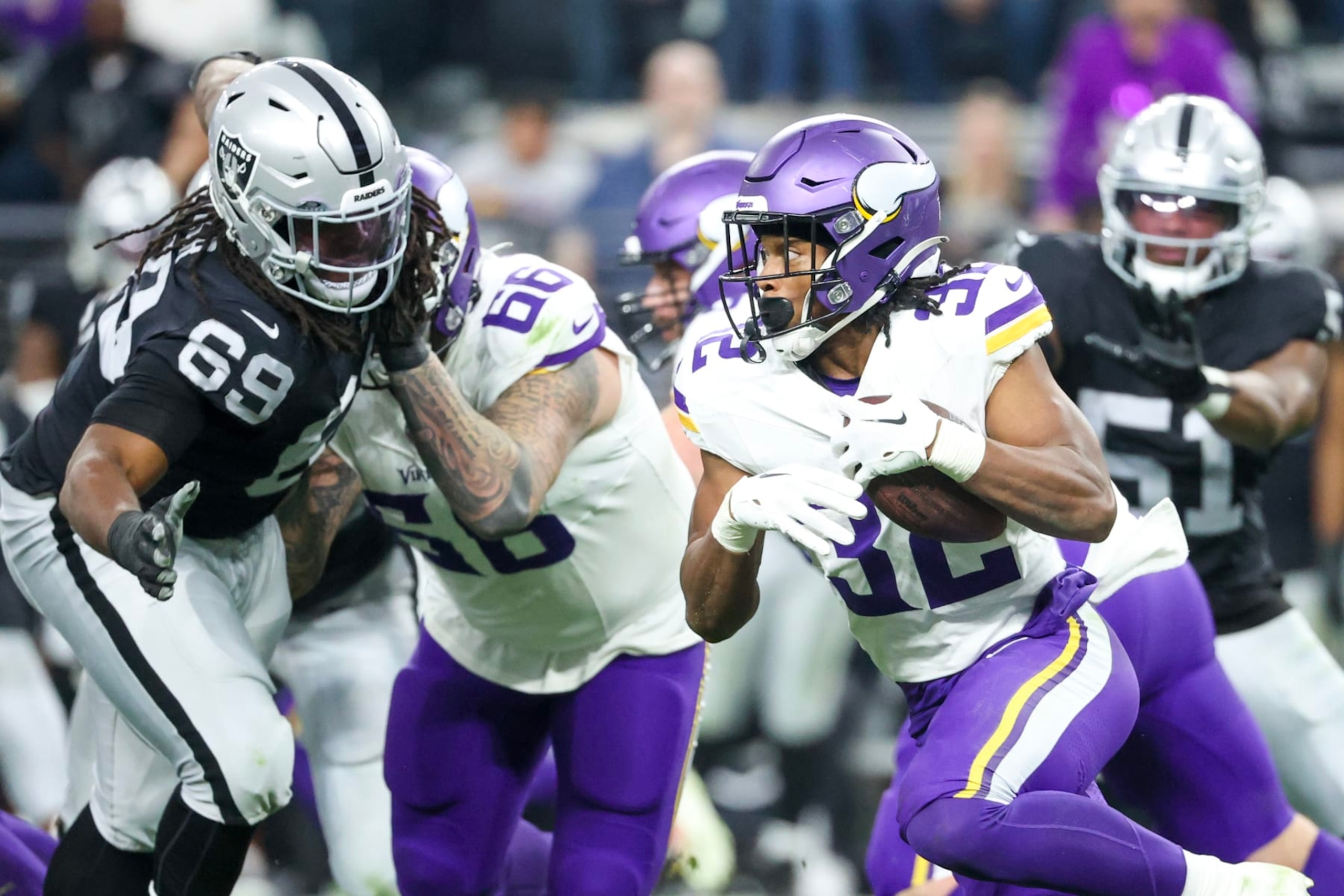 LAS VEGAS, NEVADA - DECEMBER 10: Ty Chandler #32 of the Minnesota Vikings runs past Adam Butler #69 of the Las Vegas Raiders during the third quarter at Allegiant Stadium on December 10, 2023 in Las Vegas, Nevada. (Photo by Ian Maule/Getty Images)