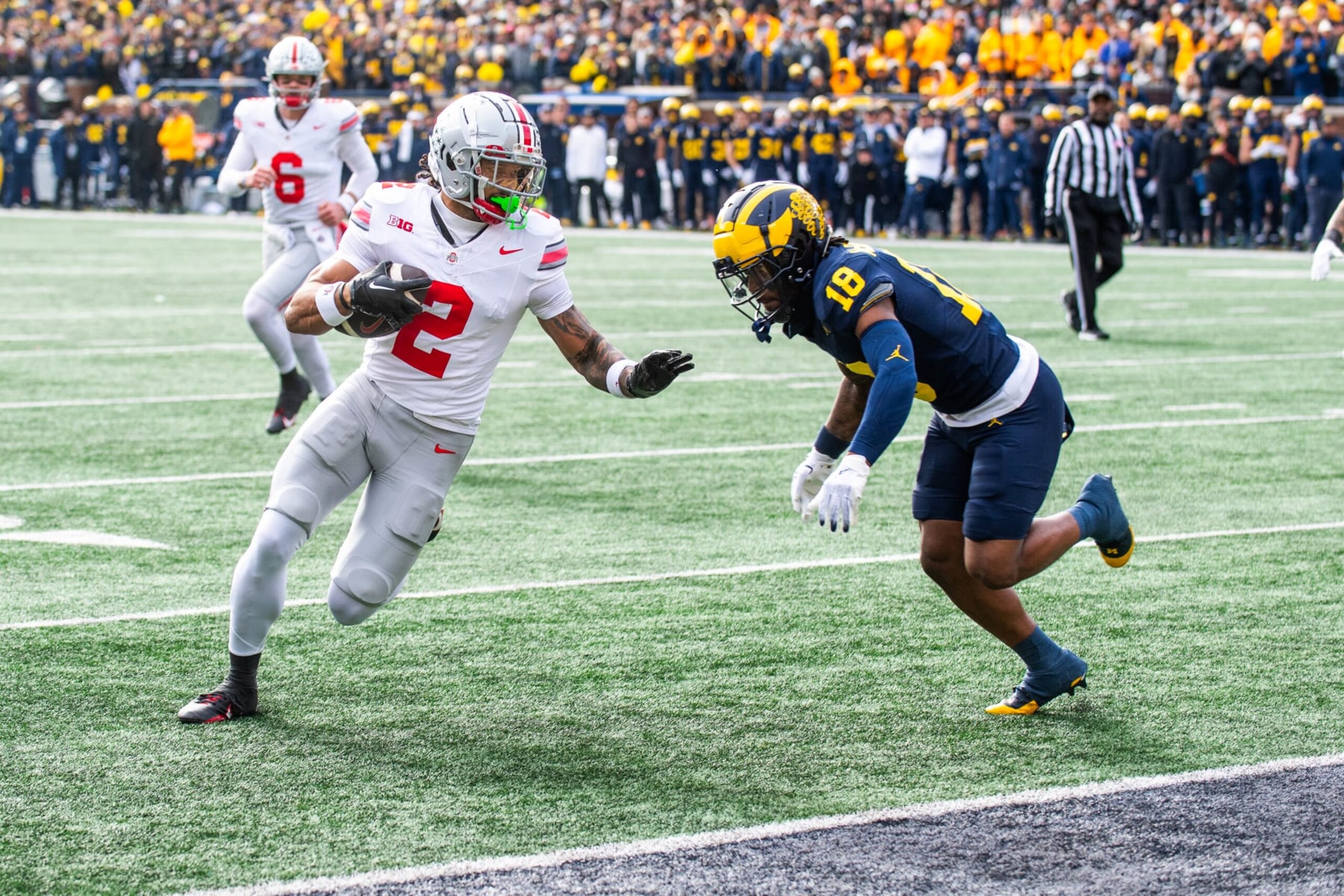 ANN ARBOR, MICHIGAN - NOVEMBER 25: Emeka Egbuka #2 of the Ohio State Buckeyes runs for yardage as Ja'Den McBurrows #18 of the Michigan Wolverines pursues during the first half of a college football game at Michigan Stadium on November 25, 2023 in Ann Arbor, Michigan. (Photo by Aaron J. Thornton/Getty Images)