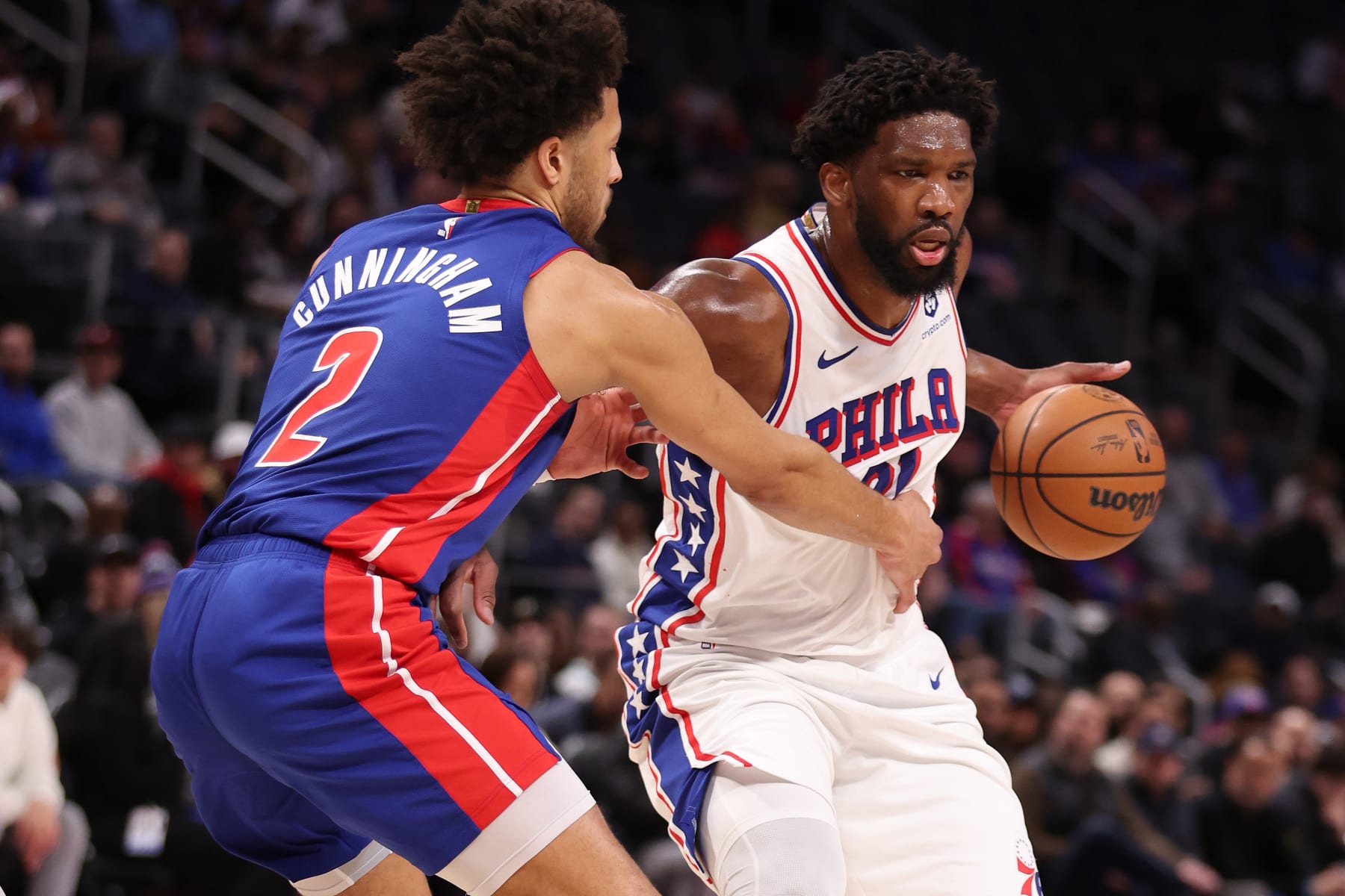 DETROIT, MICHIGAN - DECEMBER 13: Joel Embiid #21 of the Philadelphia 76ers drives around Cade Cunningham #2 of the Detroit Pistons during the first half at Little Caesars Arena on December 13, 2023 in Detroit, Michigan. NOTE TO USER: User expressly acknowledges and agrees that, by downloading and or using this photograph, User is consenting to the terms and conditions of the Getty Images License Agreement. (Photo by Gregory Shamus/Getty Images)