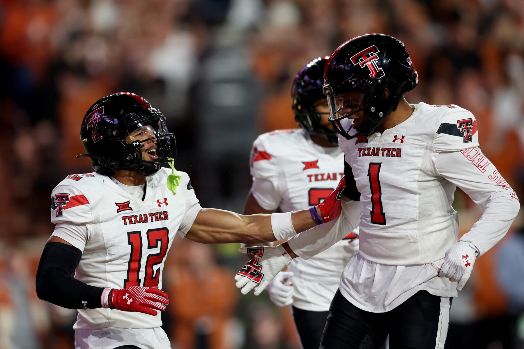 AUSTIN, TEXAS - NOVEMBER 24: Bralyn Lux #12 of the Texas Tech Red Raiders celebrates with Dadrion Taylor-Demerson #1 after an interception in the first half against the Texas Longhorns at Darrell K Royal-Texas Memorial Stadium on November 24, 2023 in Austin, Texas. (Photo by Tim Warner/Getty Images)