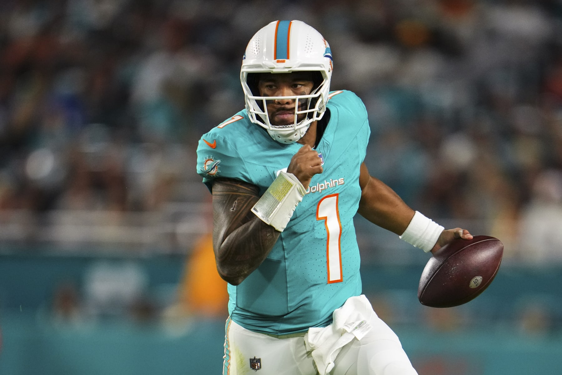 MIAMI GARDENS, FL - DECEMBER 11: Tua Tagovailoa #1 of the Miami Dolphins scrambles out of the pocket during an NFL football game against the Tennessee Titans at Hard Rock Stadium on December 11, 2023 in Miami Gardens, Florida. (Photo by Cooper Neill/Getty Images)