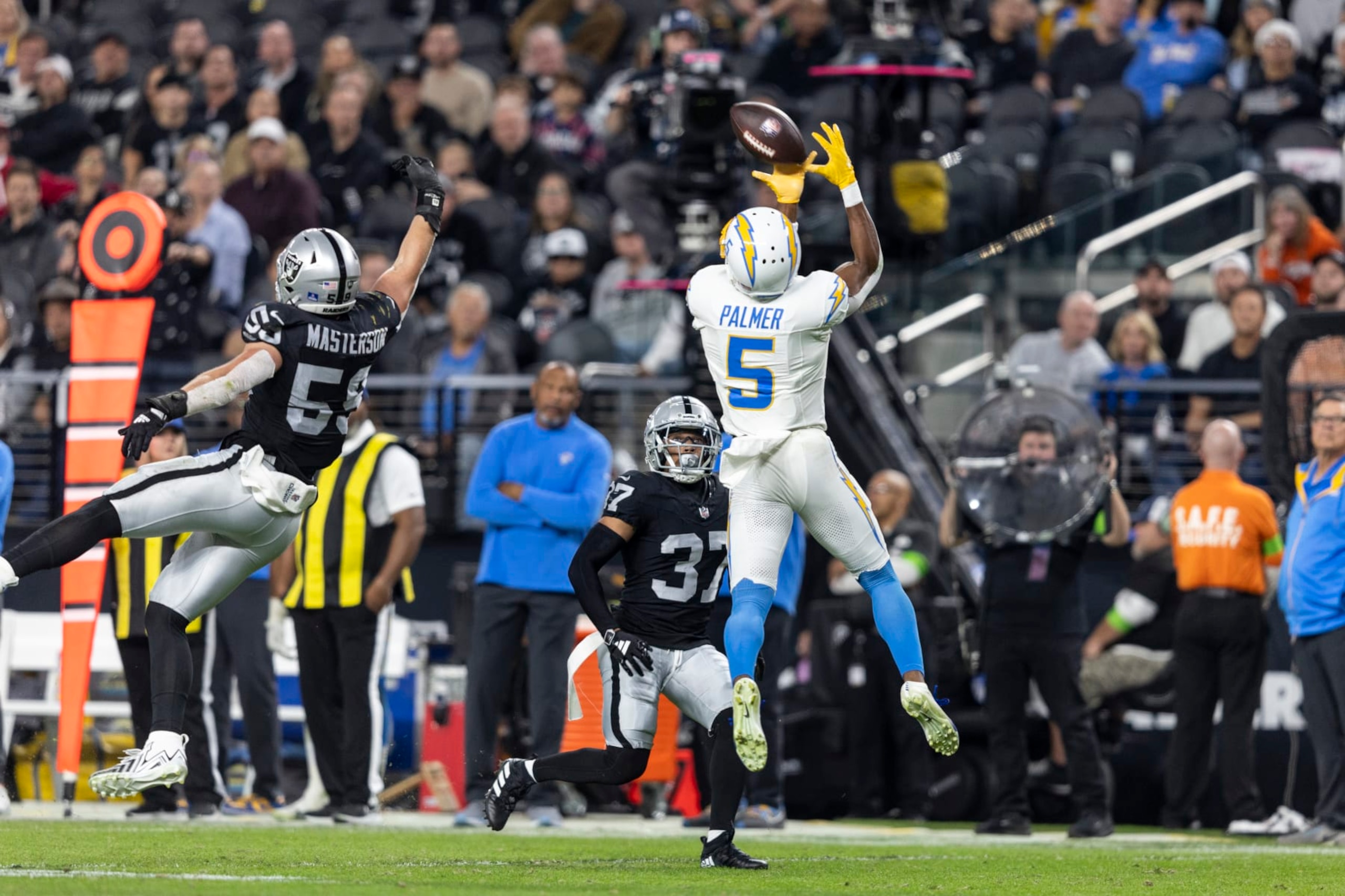 LAS VEGAS, NEVADA - DECEMBER 14: Joshua Palmer #5 of the Los Angeles Chargers completes a pass against Luke Masterson #59 of the Las Vegas Raiders during an NFL football game between the Las Vegas Raiders and the Los Angeles Chargers at Allegiant Stadium on December 14, 2023 in Las Vegas, Nevada. (Photo by Michael Owens/Getty Images)