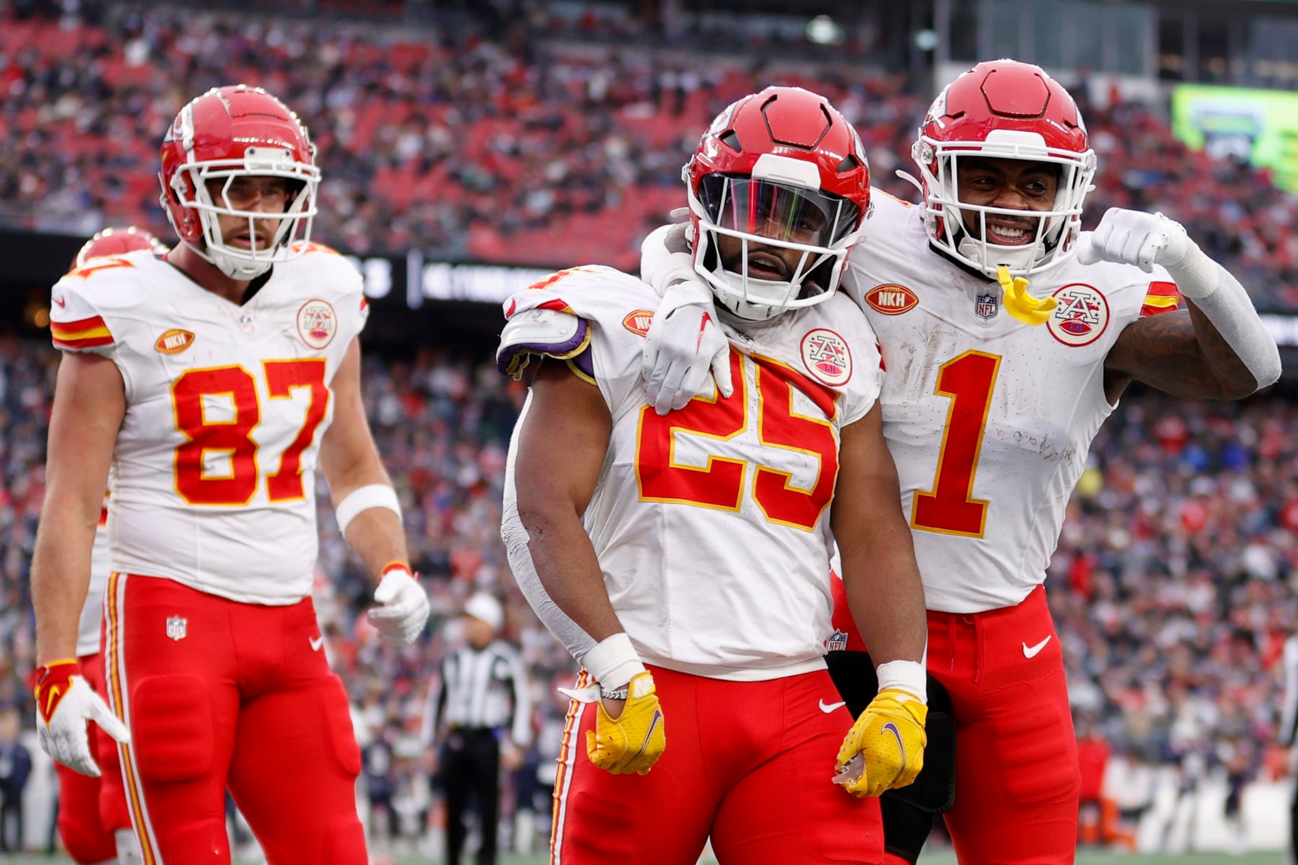 FOXBOROUGH, MASSACHUSETTS - DECEMBER 17: Travis Kelce #87, Clyde Edwards-Helaire #25 and Jerick McKinnon #1 of the Kansas City Chiefs celebrate after Edwards-Helaire's receiving touchdown during the third quarter against the New England Patriots at Gillette Stadium on December 17, 2023 in Foxborough, Massachusetts. (Photo by Sarah Stier/Getty Images)