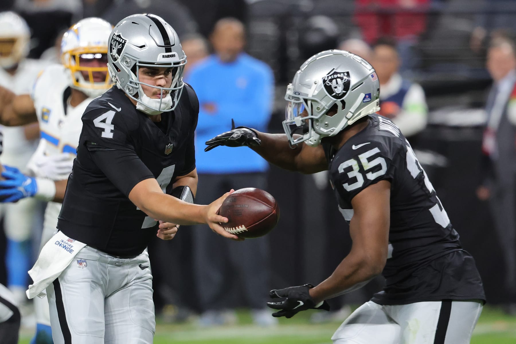 LAS VEGAS, NEVADA - DECEMBER 14: Quarterback Aidan O'Connell #4 of the Las Vegas Raiders hands off to running back Zamir White #35 against the Los Angeles Chargers during the second quarter at Allegiant Stadium on December 14, 2023 in Las Vegas, Nevada. (Photo by Ethan Miller/Getty Images)