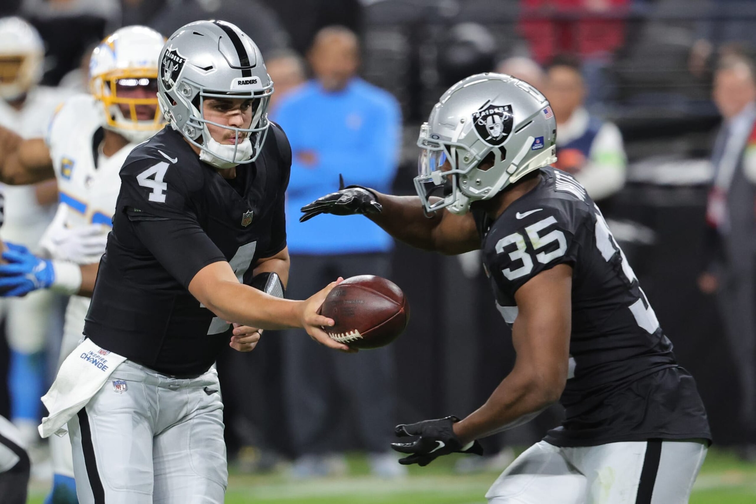 LAS VEGAS, NEVADA - DECEMBER 14: Quarterback Aidan O'Connell #4 of the Las Vegas Raiders hands off to running back Zamir White #35 against the Los Angeles Chargers during the second quarter at Allegiant Stadium on December 14, 2023 in Las Vegas, Nevada. (Photo by Ethan Miller/Getty Images)