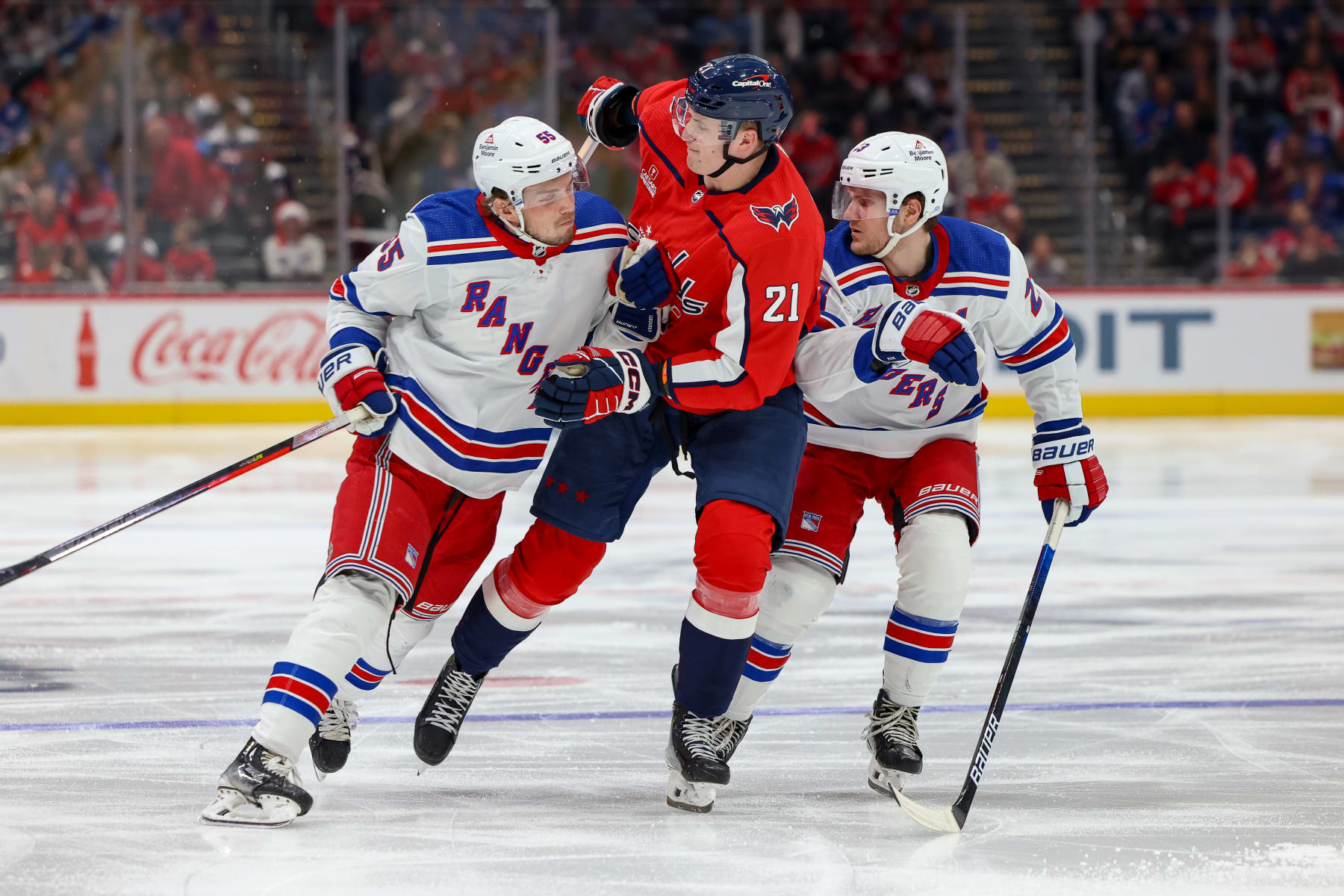 WASHINGTON, DC - DECEMBER 9: Aliaksei Protas #21 of the Washington Capitals collides with Ryan Lindgren #55 and Adam Fox #23 of the New York Rangers during a game at Capital One Arena on December 9, 2023 in Washington, D.C. (Photo by John McCreary/NHLI via Getty Images)