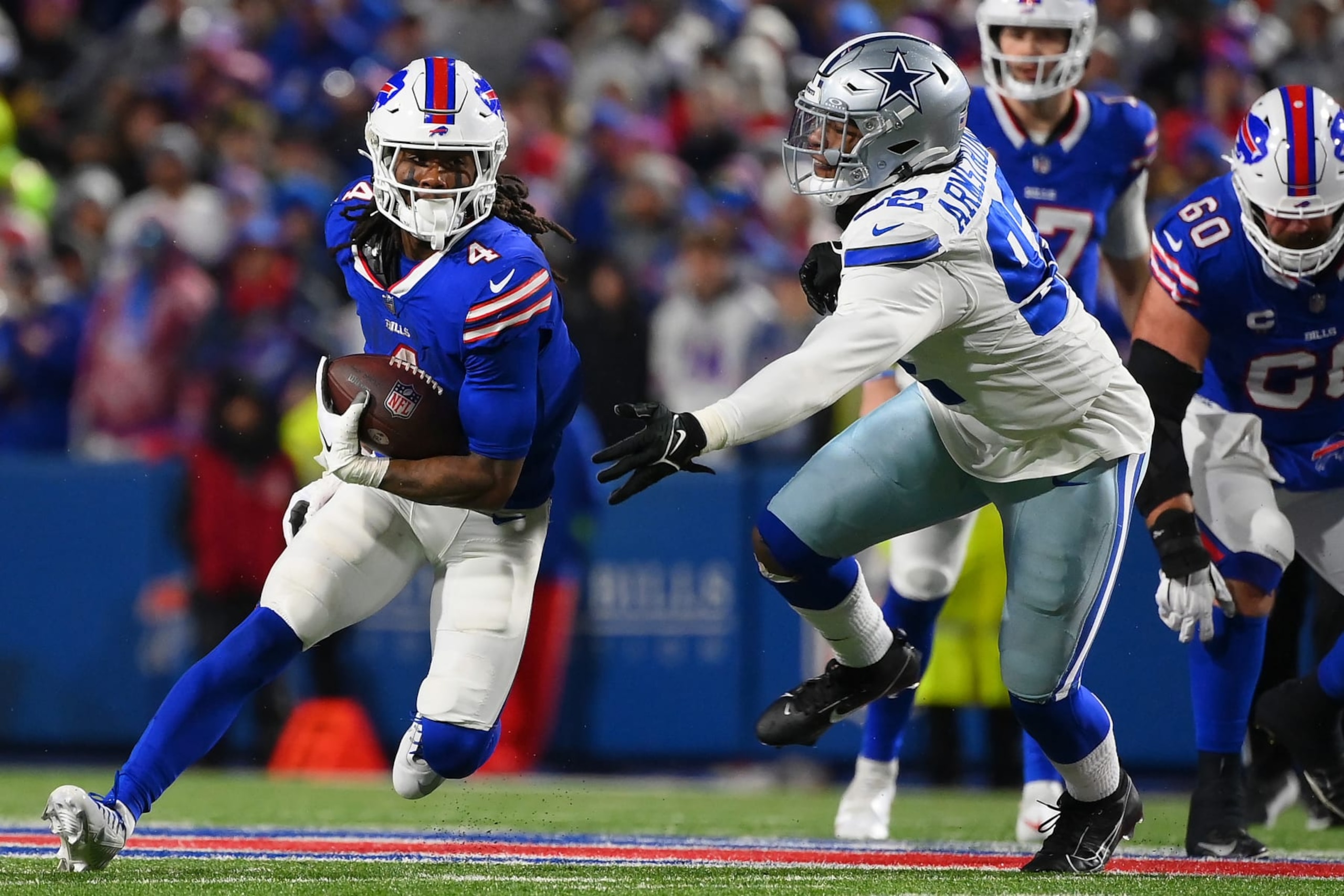ORCHARD PARK, NEW YORK - DECEMBER 17: James Cook #4 of the Buffalo Bills runs past Dorance Armstrong #92 of the Dallas Cowboys during the second quarter at Highmark Stadium on December 17, 2023 in Orchard Park, New York. (Photo by Rich Barnes/Getty Images)