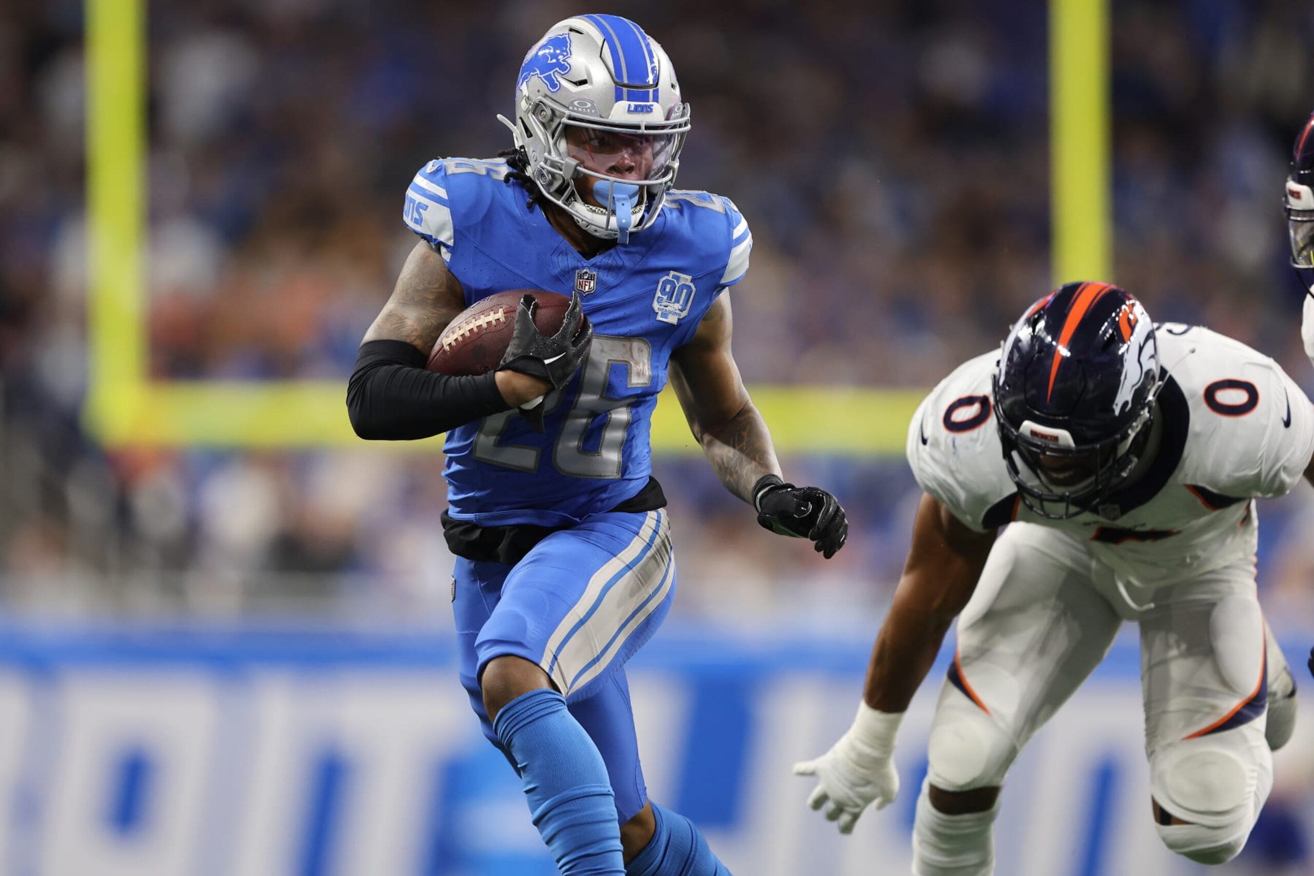 DETROIT, MICHIGAN - DECEMBER 16: Jahmyr Gibbs #26 of the Detroit Lions runs the ball against Jonathon Cooper #0 of the Denver Broncos during the third quarter at Ford Field on December 16, 2023 in Detroit, Michigan. (Photo by Rey Del Rio/Getty Images)