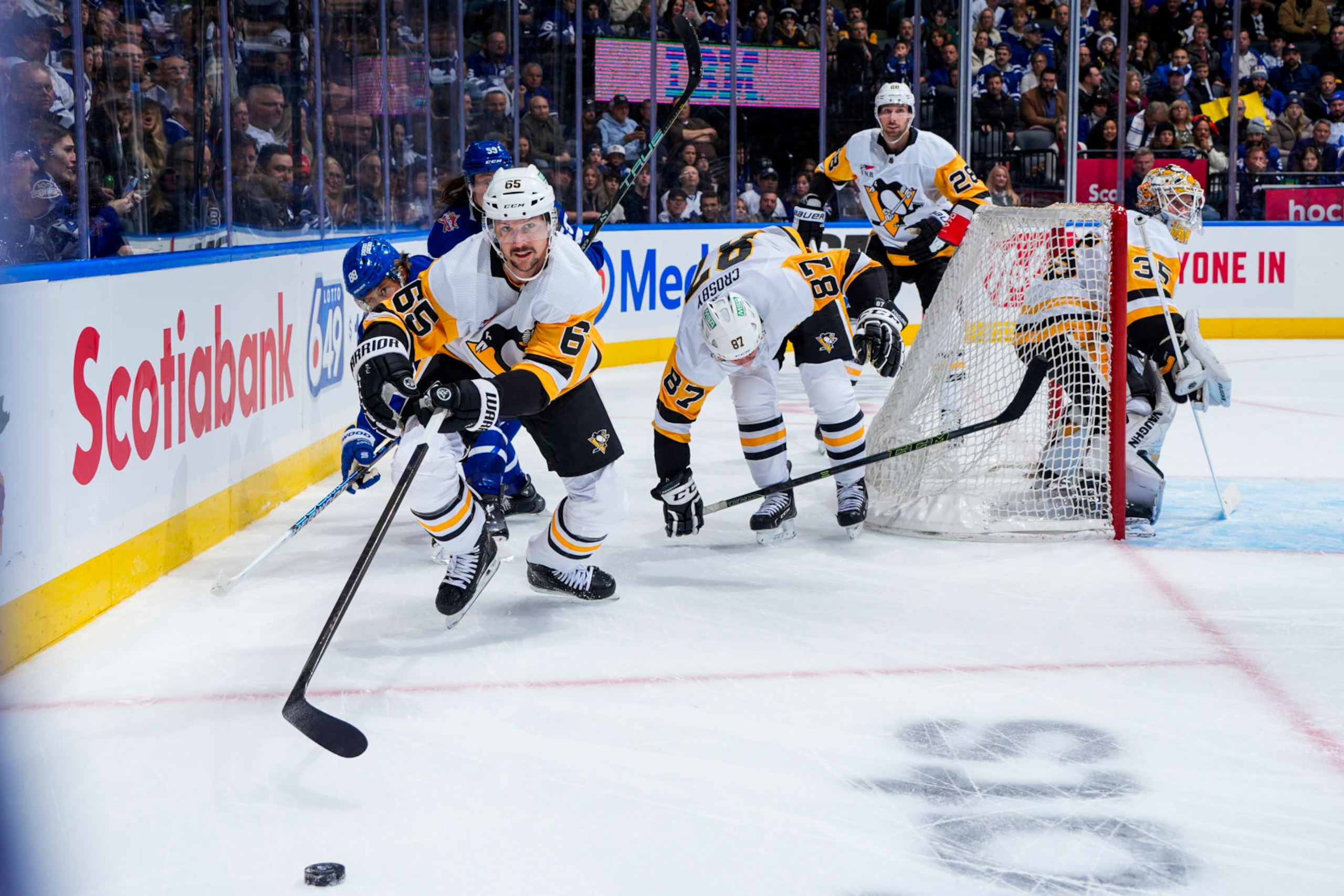 TORONTO, ON - DECEMBER 16: Erik Karlsson #65 of the Pittsburgh Penguins reaches for the puck against the Toronto Maple Leafs during the first period at the Scotiabank Arena on December 16, 2023 in Toronto, Ontario, Canada. (Photo by Mark Blinch/NHLI via Getty Images)