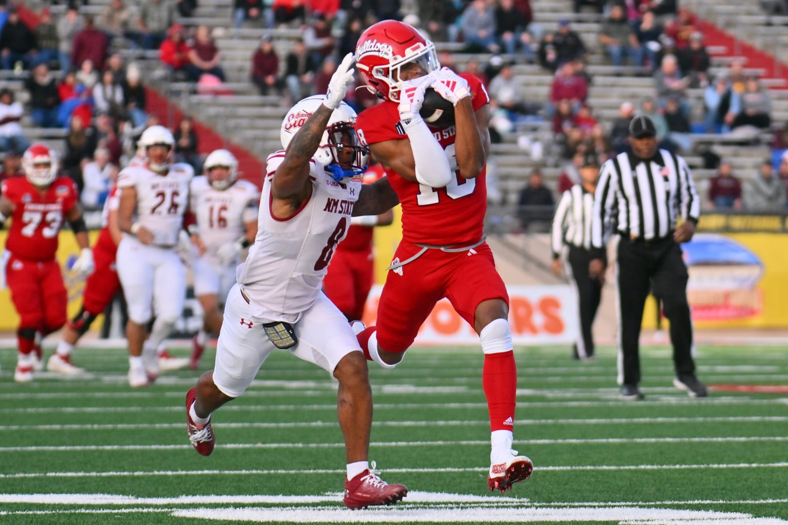 ALBUQUERQUE, NEW MEXICO - DECEMBER 16: Wide receiver Jalen Moss #18 of the Fresno State Bulldogs catches a pass against cornerback Andre Seldon #8 of the New Mexico State Aggies during the first half of the Isleta New Mexico Bowl at University Stadium on December 16, 2023 in Albuquerque, New Mexico. (Photo by Sam Wasson/Getty Images) ALBUQUERQUE, NEW MEXICO - DECEMBER 16: Wide receiver Jalen Moss #18 of the Fresno State Bulldogs catches a pass against cornerback Andre Seldon #8 of the New Mexico State Aggies during the first half of the Isleta New Mexico Bowl at University Stadium on December 16, 2023 in Albuquerque, New Mexico. (Photo by Sam Wasson/Getty Images)