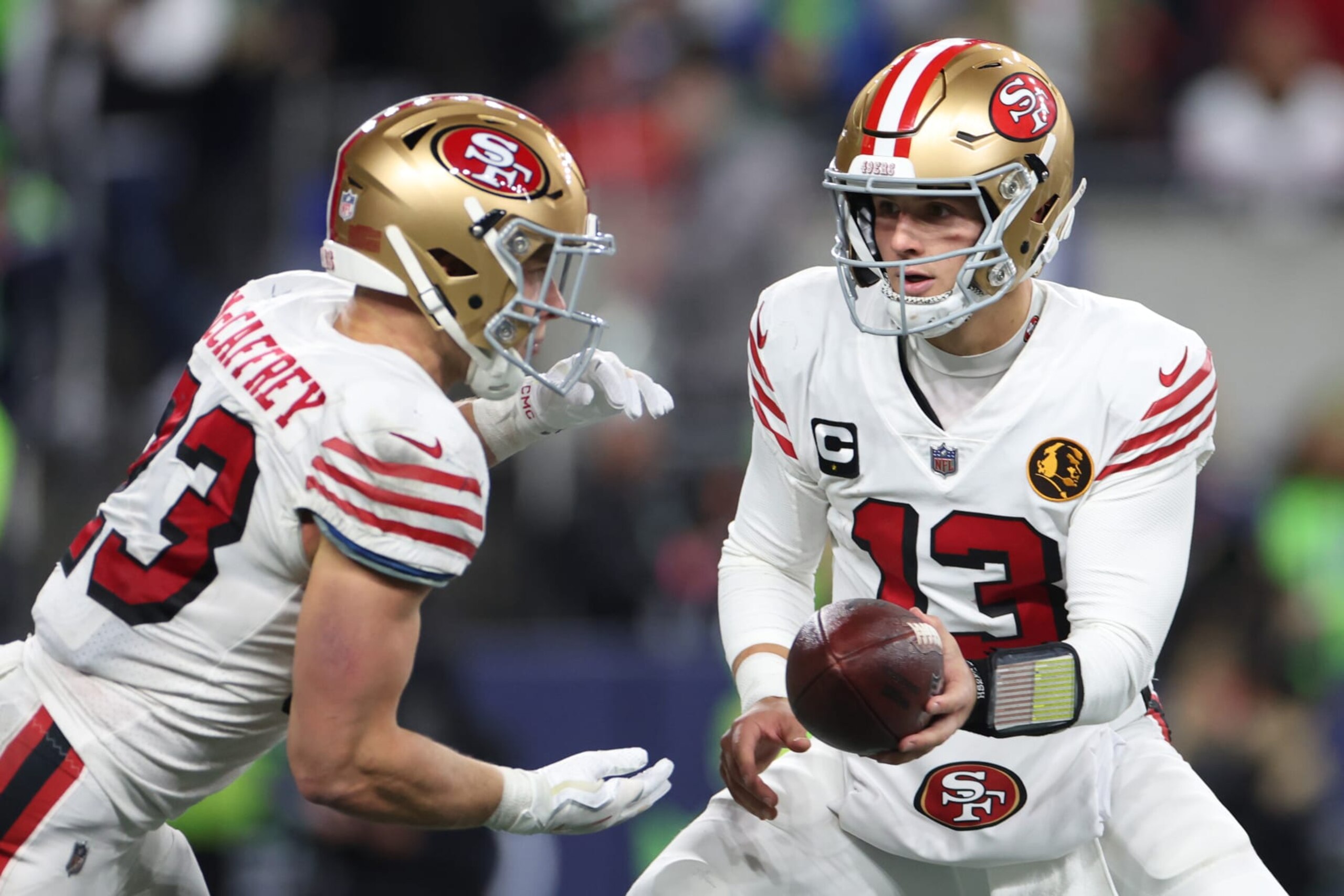 SEATTLE, WASHINGTON - NOVEMBER 23: Brock Purdy #13 of the San Francisco 49ers hands off the ball to Christian McCaffrey #23 of the San Francisco 49ers during the second quarter against the Seattle Seahawks at Lumen Field on November 23, 2023 in Seattle, Washington. (Photo by Steph Chambers/Getty Images)