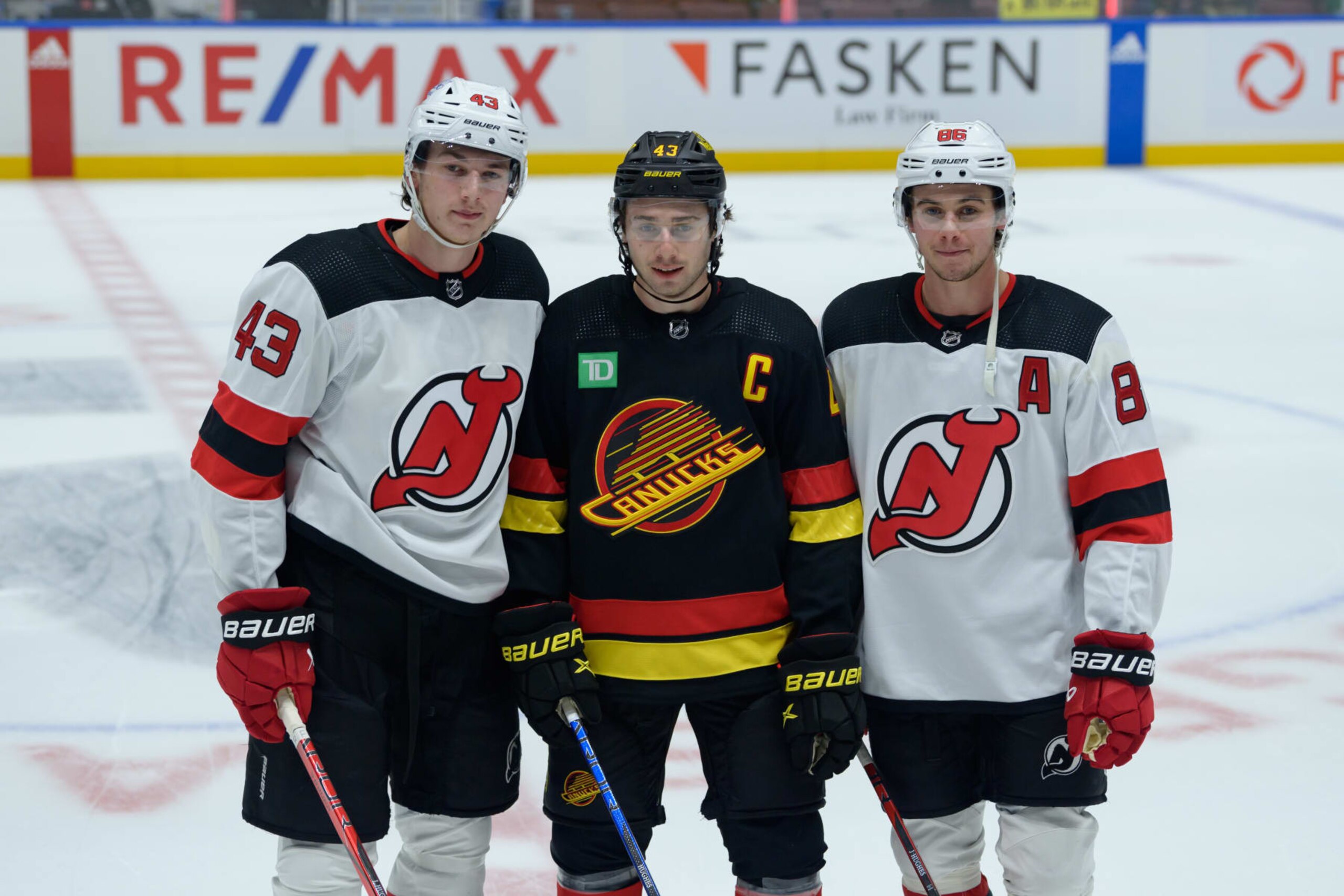 VANCOUVER, CANADA - DECEMBER 5: Brothers Quinn Hughes #43 (C) of the Vancouver Canucks, Jack Hughes #86 (R) and Luke Hughes #43 of the New Jersey Devils pose for a photo prior to their NHL game at Rogers Arena on December 5, 2023 in Vancouver, British Columbia, Canada. (Photo by Derek Cain/Getty Images)