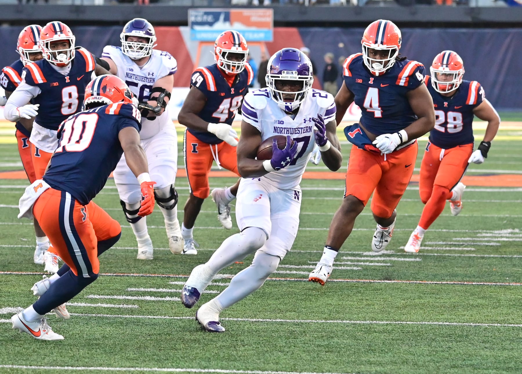 CHAMPAIGN, IL - NOVEMBER 25: Northwestern running back Anthony Tyus III (27) eludes a hist of Illini tacklers as he runs the ball during a college football game between the Northwestern Wildcats and the Illinois Fighting Illini on November 25, 2023, at Memorial Stadium in Champaign, IL. (Photo by Keith Gillett/Icon Sportswire via Getty Images)