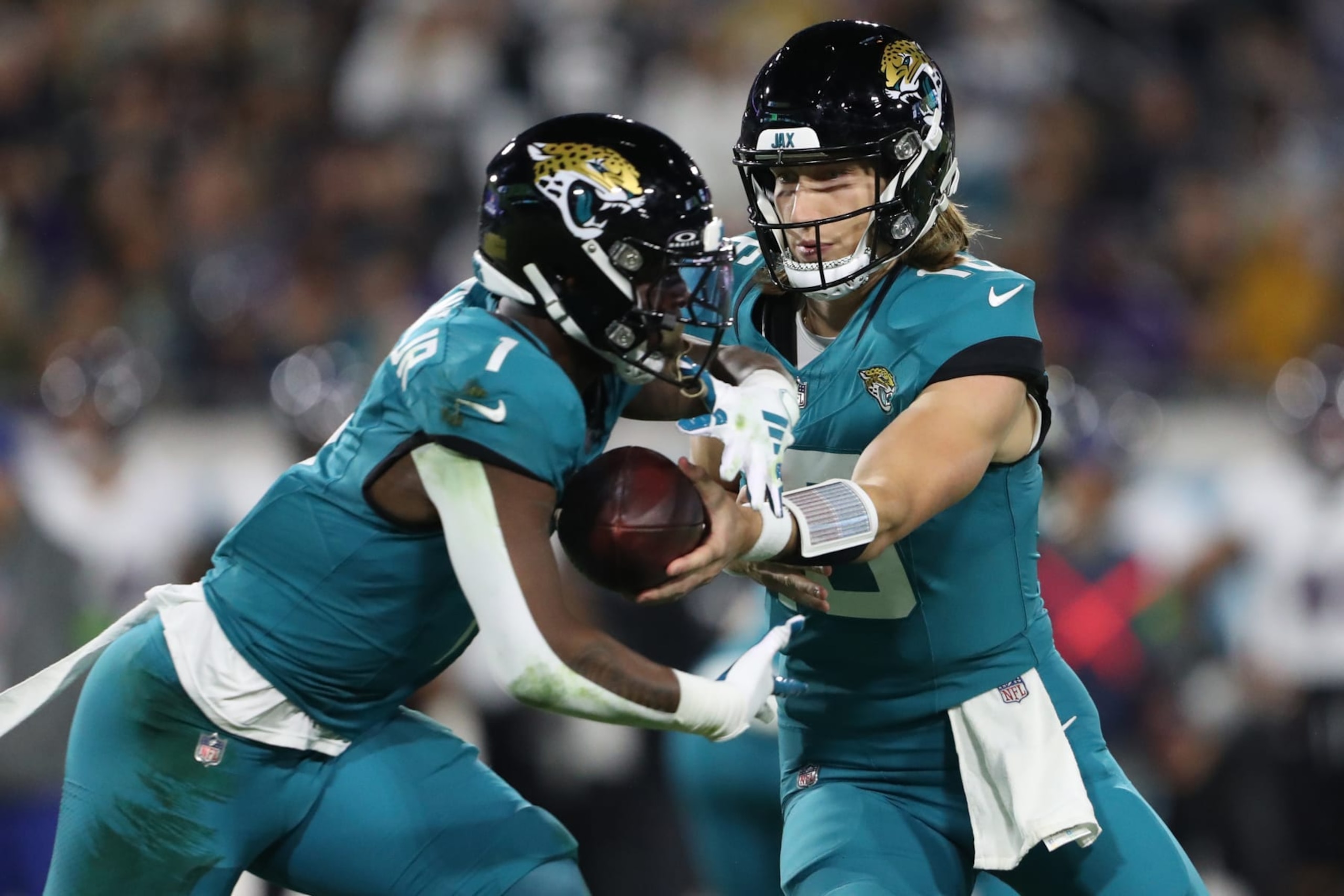 JACKSONVILLE, FLORIDA - DECEMBER 17: Trevor Lawrence #16 of the Jacksonville Jaguars hands the ball to Travis Etienne Jr. #1 during the first quarter against the Baltimore Ravens at EverBank Stadium on December 17, 2023 in Jacksonville, Florida. (Photo by Courtney Culbreath/Getty Images)