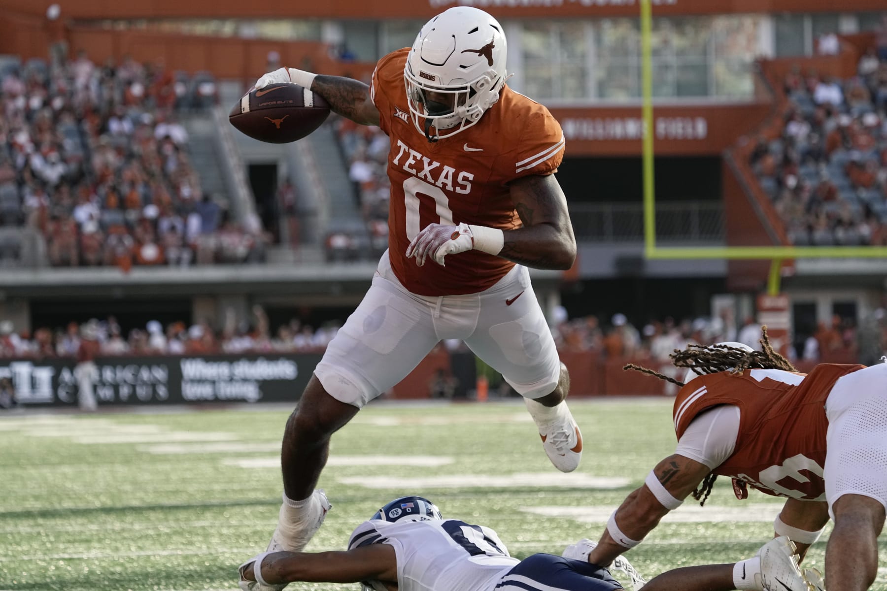 Texas tight end Ja'Tavion Sanders (0) is tripped up just short of the goal line by BYU cornerback Jakob Robinson, bottom, during the second half of an NCAA college football game in Austin, Texas, Saturday, Oct. 28, 2023. (AP Photo/Eric Gay)