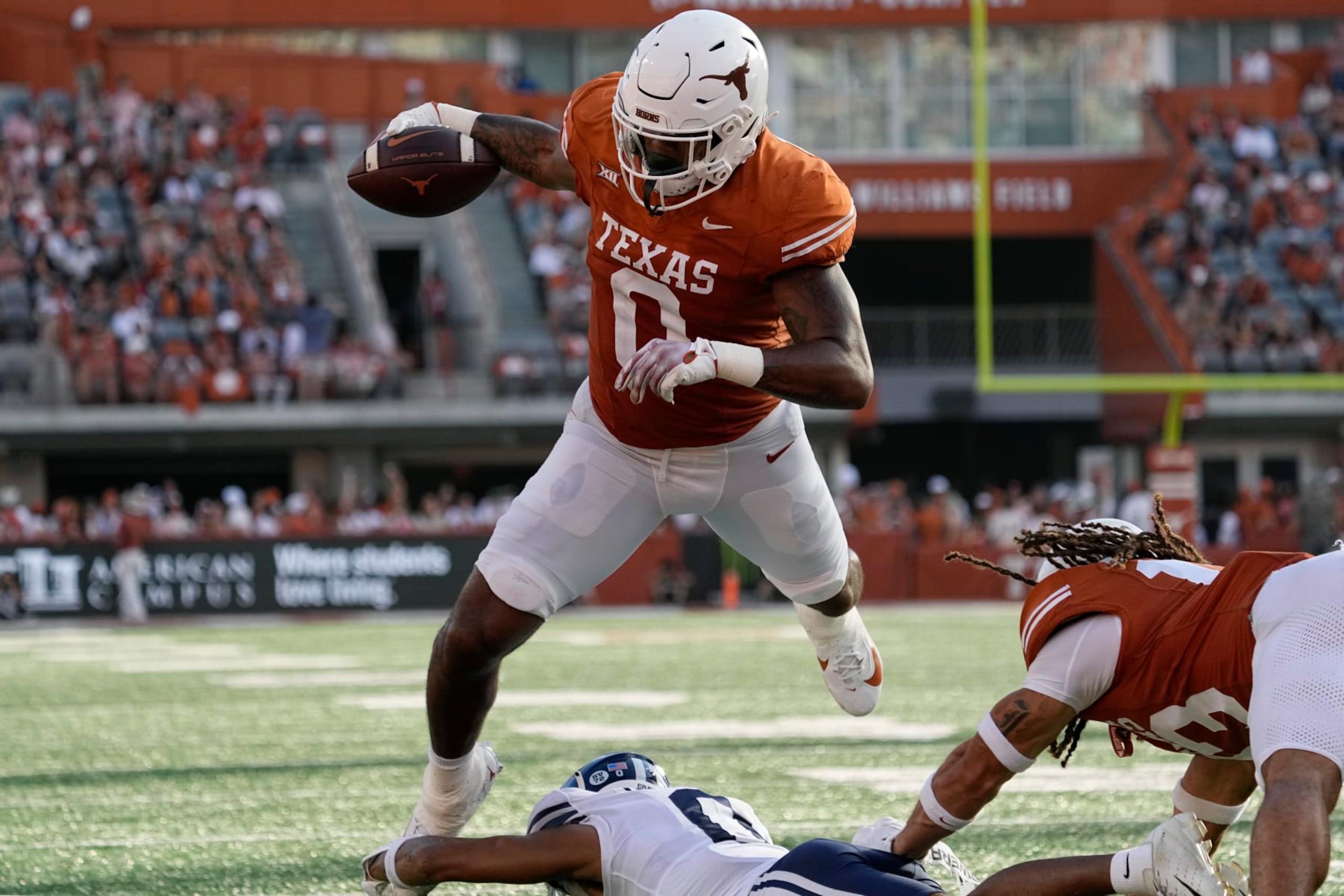 Texas tight end Ja'Tavion Sanders (0) is tripped up just short of the goal line by BYU cornerback Jakob Robinson, bottom, during the second half of an NCAA college football game in Austin, Texas, Saturday, Oct. 28, 2023. (AP Photo/Eric Gay)