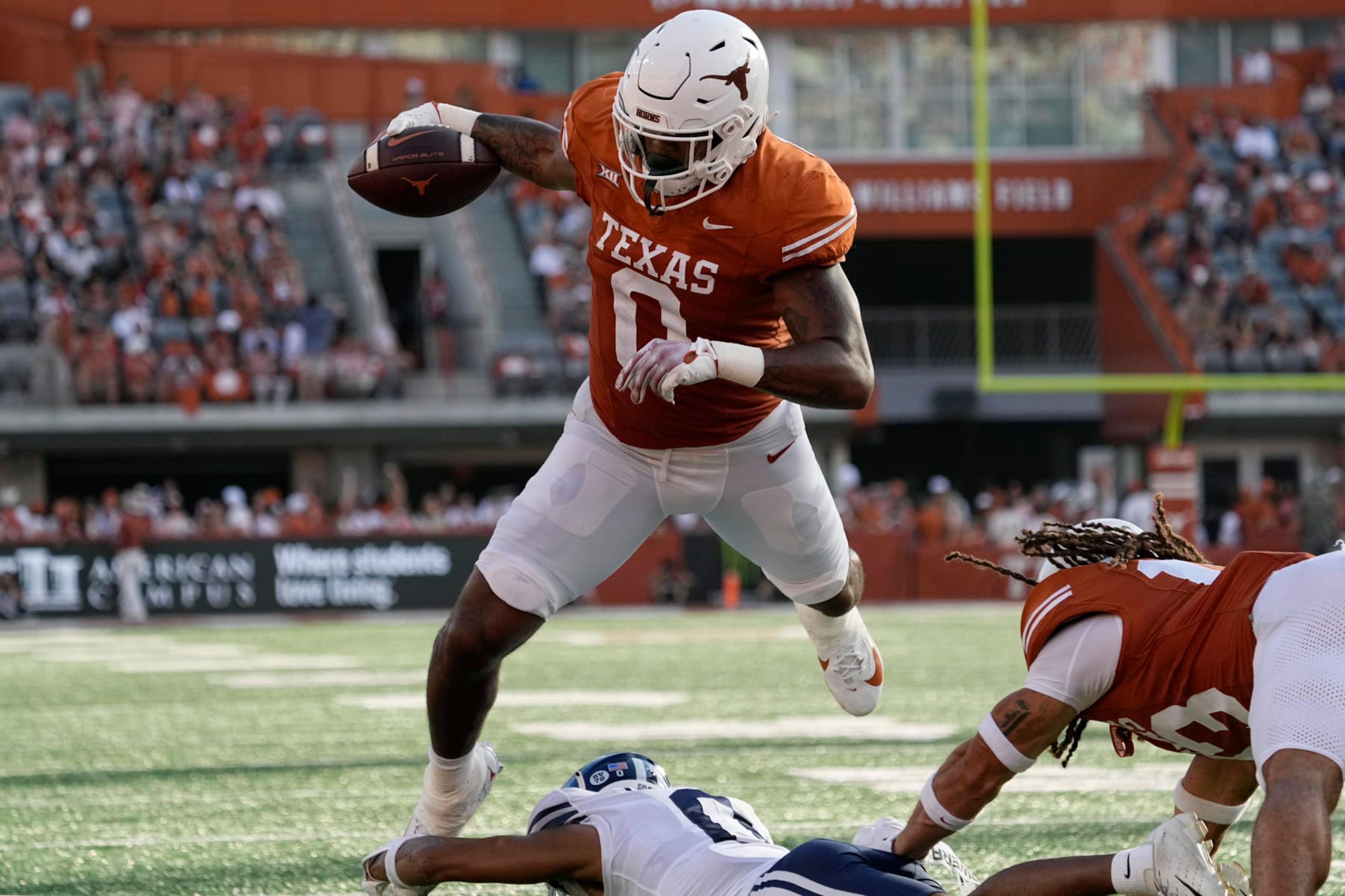 Texas tight end Ja'Tavion Sanders (0) is tripped up just short of the goal line by BYU cornerback Jakob Robinson, bottom, during the second half of an NCAA college football game in Austin, Texas, Saturday, Oct. 28, 2023. (AP Photo/Eric Gay)