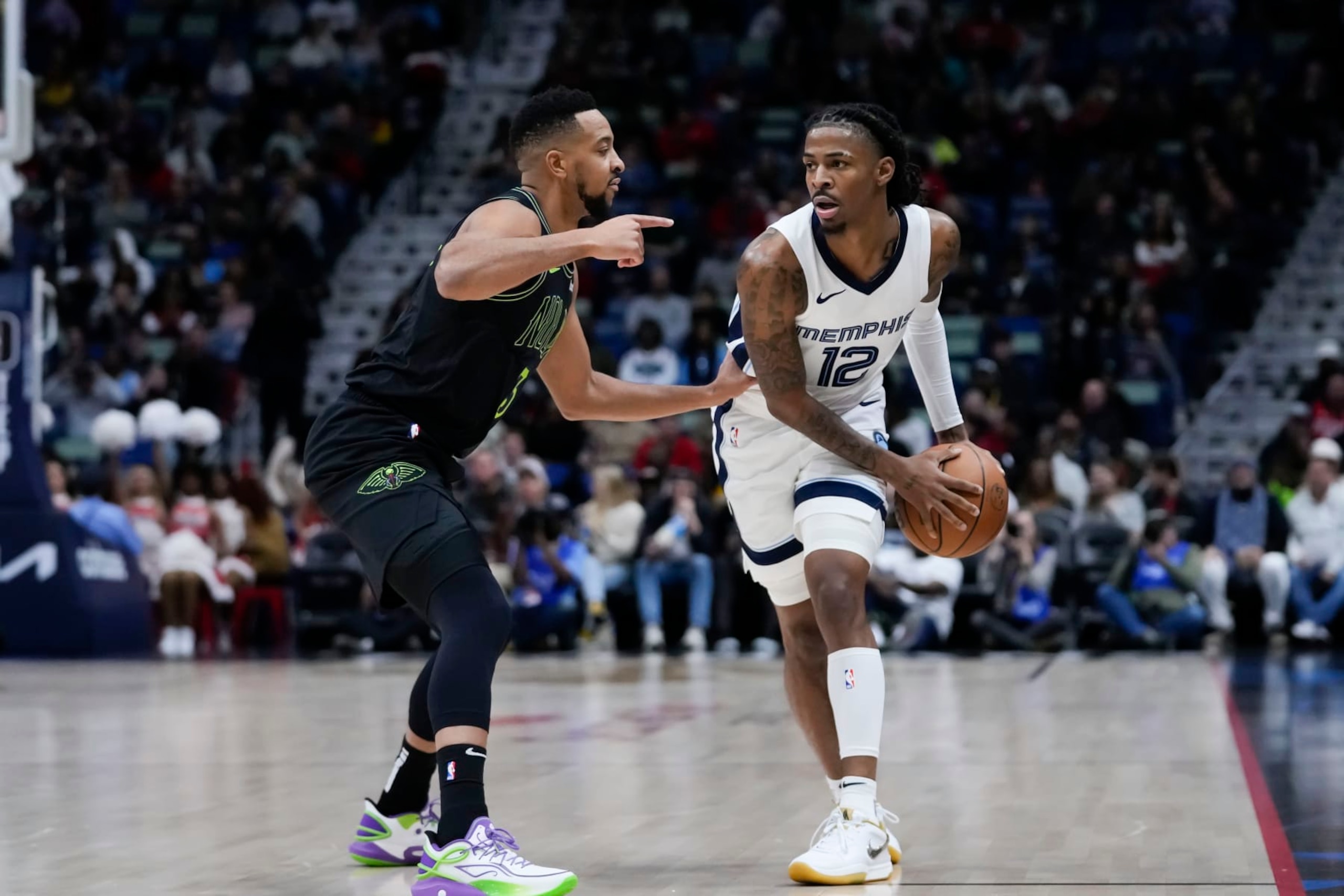Memphis Grizzlies guard Ja Morant (12) looks to pass around New Orleans Pelicans guard CJ McCollum (3) in the first half of an NBA basketball game in New Orleans, Tuesday, Dec. 19, 2023. (AP Photo/Gerald Herbert) Memphis Grizzlies guard Ja Morant (12) looks to pass around New Orleans Pelicans guard CJ McCollum (3) in the first half of an NBA basketball game in New Orleans, Tuesday, Dec. 19, 2023. (AP Photo/Gerald Herbert)