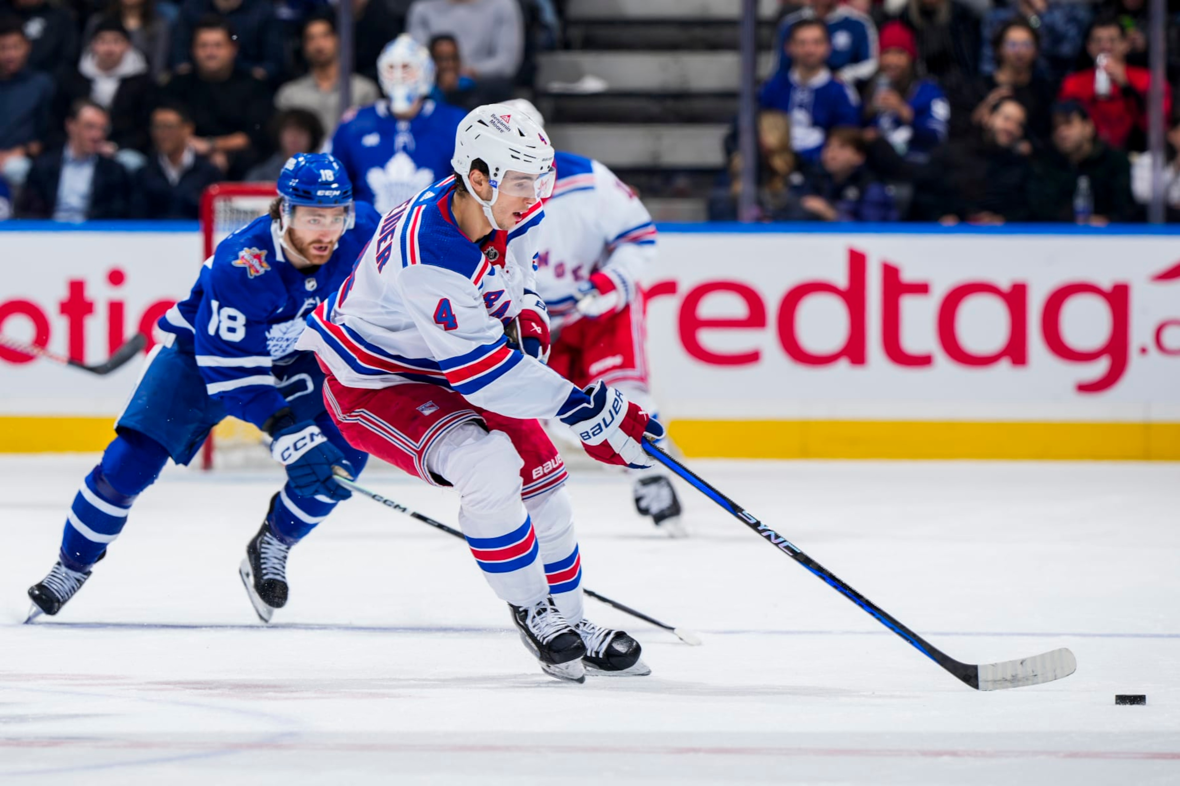 TORONTO, ON - DECEMBER 19: Braden Schneider #4 of the New York Rangers plays the puck against Noah Gregor #18 of the Toronto Maple Leafs during the first period at Scotiabank Arena on December 19, 2023 in Toronto, Ontario, Canada. (Photo by Mark Blinch/NHLI via Getty Images) TORONTO, ON - DECEMBER 19: Braden Schneider #4 of the New York Rangers plays the puck against Noah Gregor #18 of the Toronto Maple Leafs during the first period at Scotiabank Arena on December 19, 2023 in Toronto, Ontario, Canada. (Photo by Mark Blinch/NHLI via Getty Images)