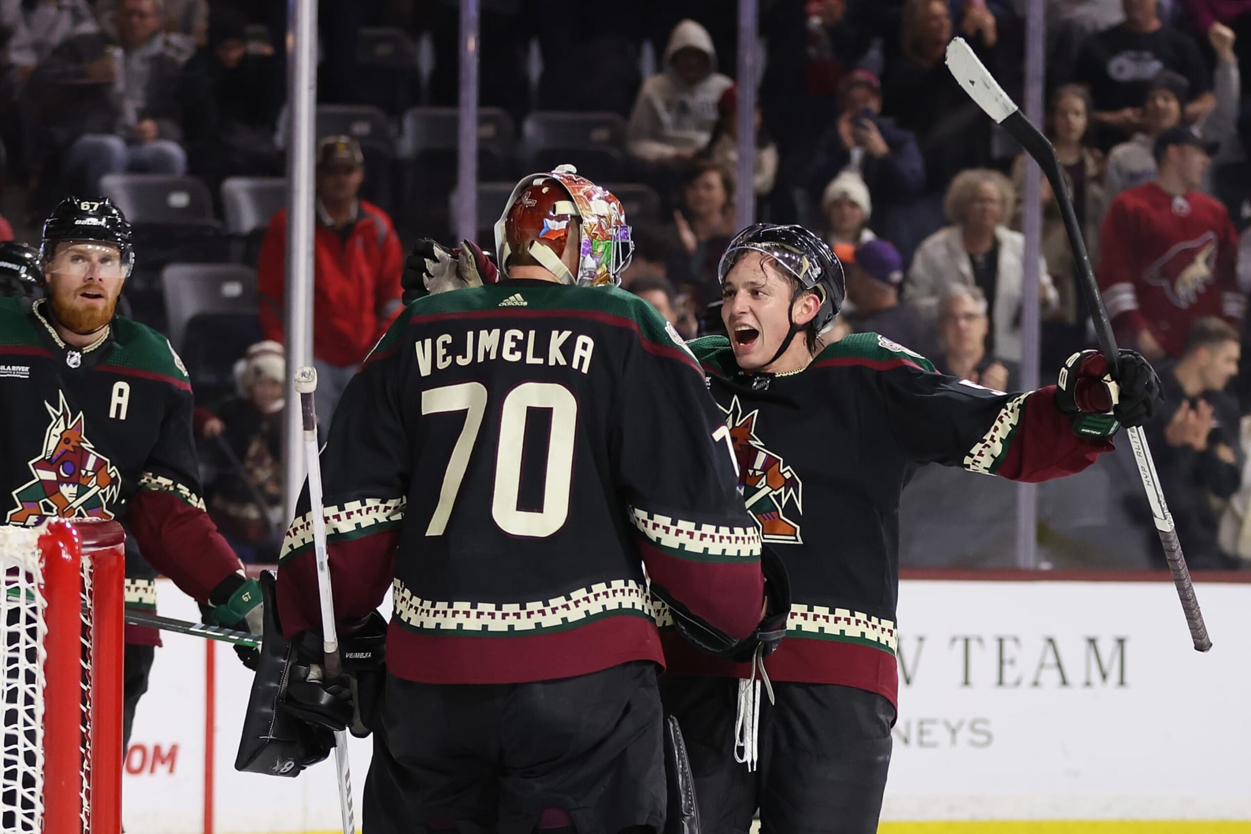 TEMPE, ARIZONA - DECEMBER 19: Troy Stecher #51 of the Arizona Coyotes celebrates with goaltender Karel Vejmelka #70 after defeating the Ottawa Senators in the NHL game at Mullett Arena on December 19, 2023 in Tempe, Arizona. The Coyotes defeated the Senators 4-3.  (Photo by Christian Petersen/Getty Images)