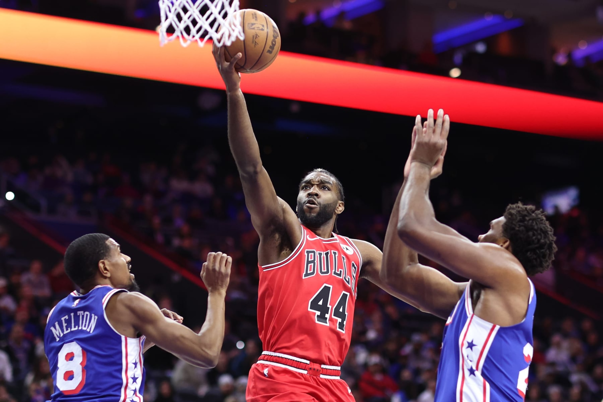 PHILADELPHIA, PENNSYLVANIA - DECEMBER 18: Patrick Williams #44 of the Chicago Bulls shoots a lay up between De'Anthony Melton #8 and Joel Embiid #21 of the Philadelphia 76ers during the first quarter at the Wells Fargo Center on December 18, 2023 in Philadelphia, Pennsylvania. NOTE TO USER: User expressly acknowledges and agrees that, by downloading and or using this photograph, User is consenting to the terms and conditions of the Getty Images License Agreement. (Photo by Tim Nwachukwu/Getty Images)