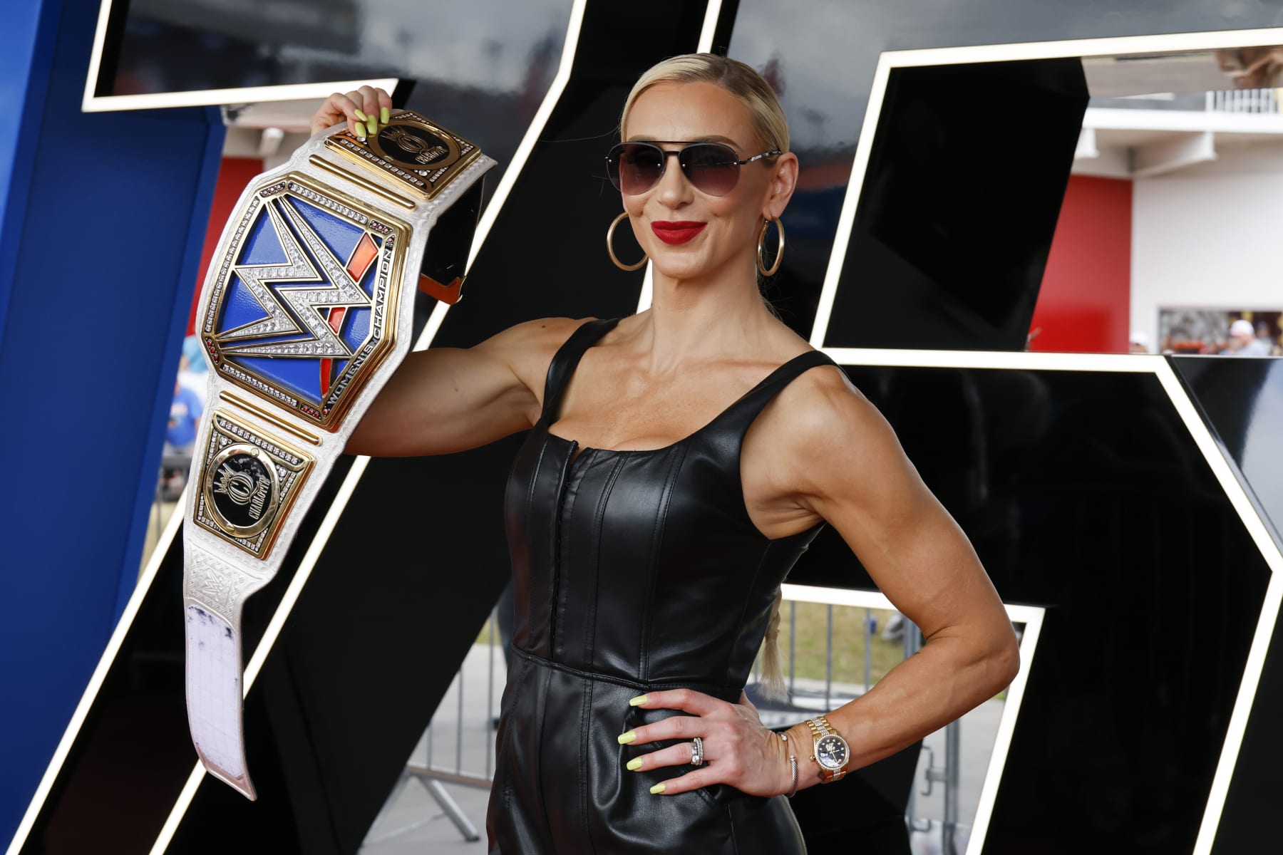 WWE Superstar Charlotte Flair shows off her championship wrestling belt as she poses for photographers during a red carpet event before the start of the NASCAR Daytona 500 auto race at Daytona International Speedway, Sunday, Feb. 19, 2023, in Daytona Beach, Fla. (AP Photo/Terry Renna)