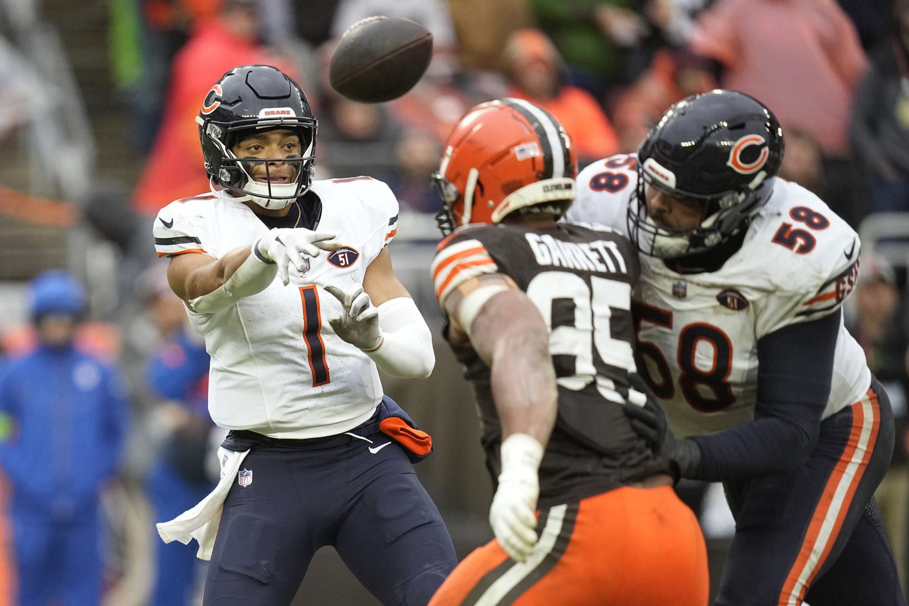 Chicago Bears quarterback Justin Fields (1) throws under pressure from Cleveland Browns defensive end Myles Garrett (95) in the first half of an NFL football game, Sunday, Dec. 17, 2023, in Cleveland. (AP Photo/Sue Ogrocki)