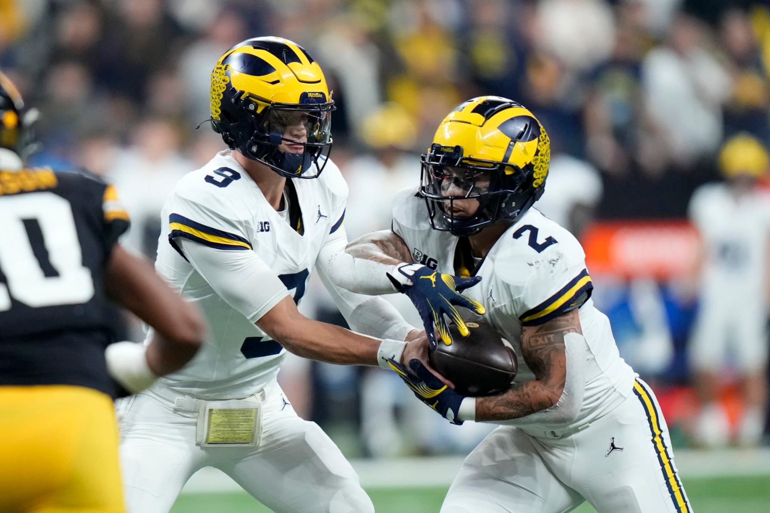 Michigan quarterback J.J. McCarthy (9) hands the ball off to running back Blake Corum (2) during the first half of the Big Ten championship NCAA college football game against Iowa, Saturday, Dec. 2, 2023, in Indianapolis. (AP Photo/AJ Mast) Michigan quarterback J.J. McCarthy (9) hands the ball off to running back Blake Corum (2) during the first half of the Big Ten championship NCAA college football game against Iowa, Saturday, Dec. 2, 2023, in Indianapolis. (AP Photo/AJ Mast)